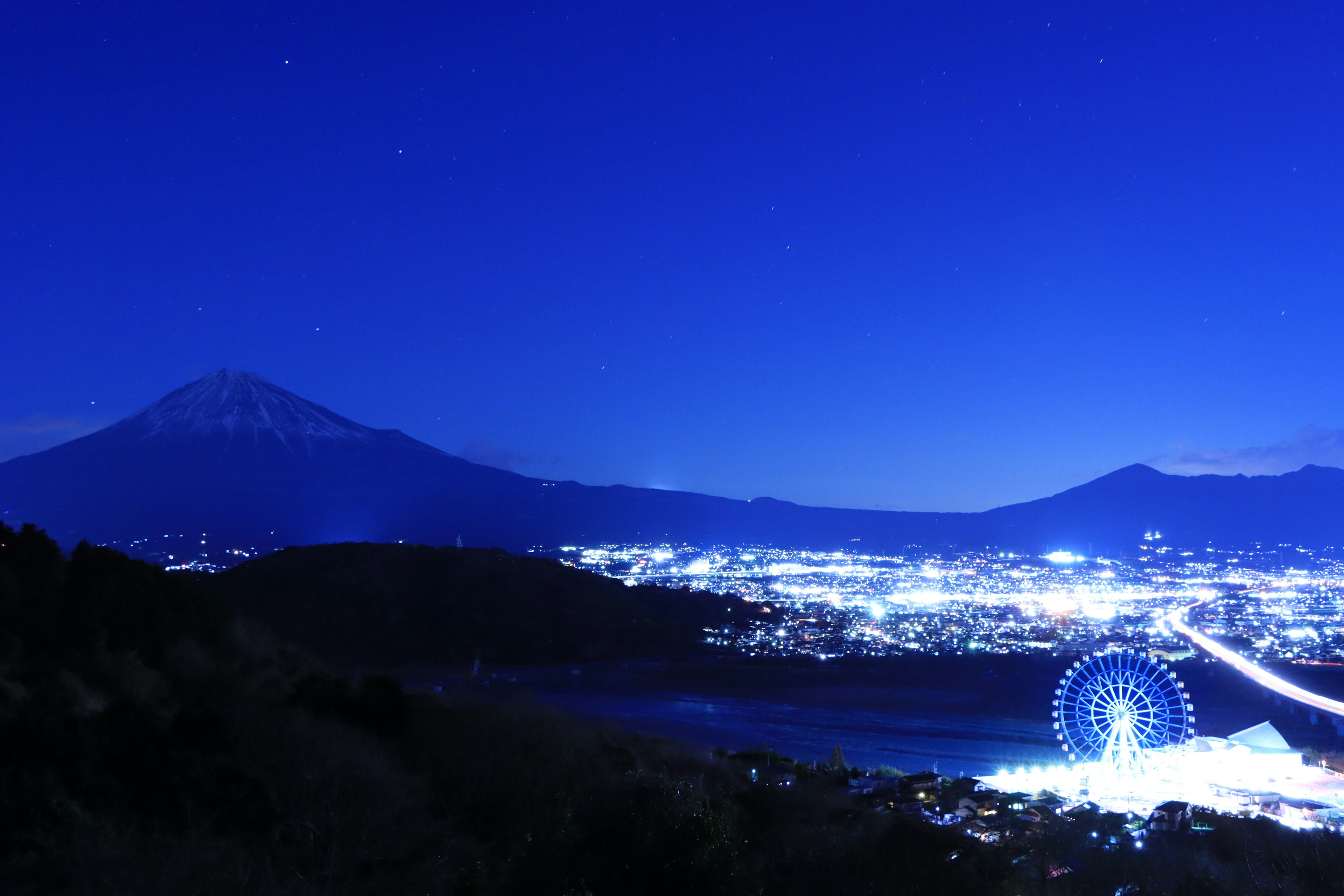 Vista spettacolare del monte Fuji e della ruota panoramica sotto il cielo notturno