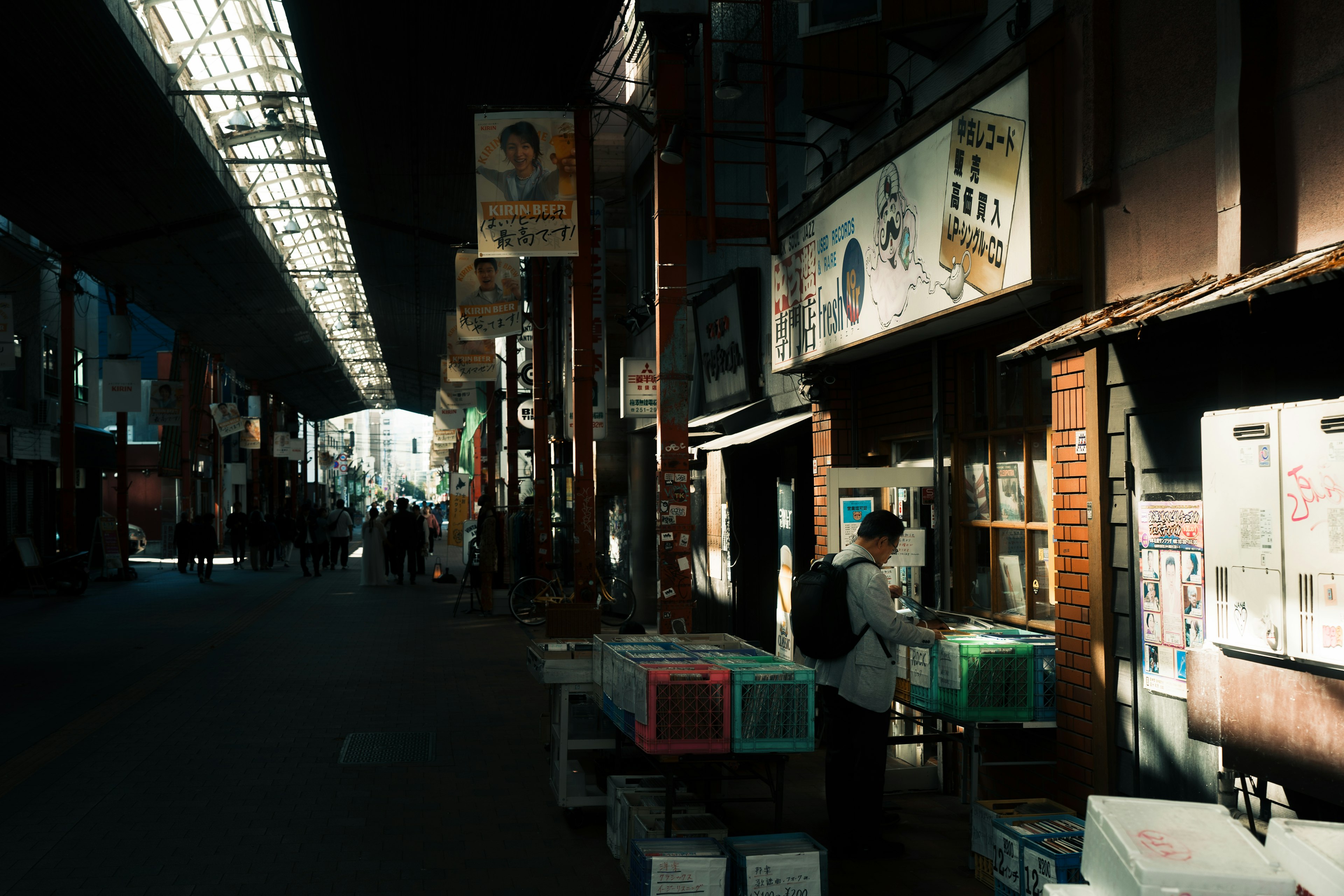 Dimly lit market street with vendors and signage