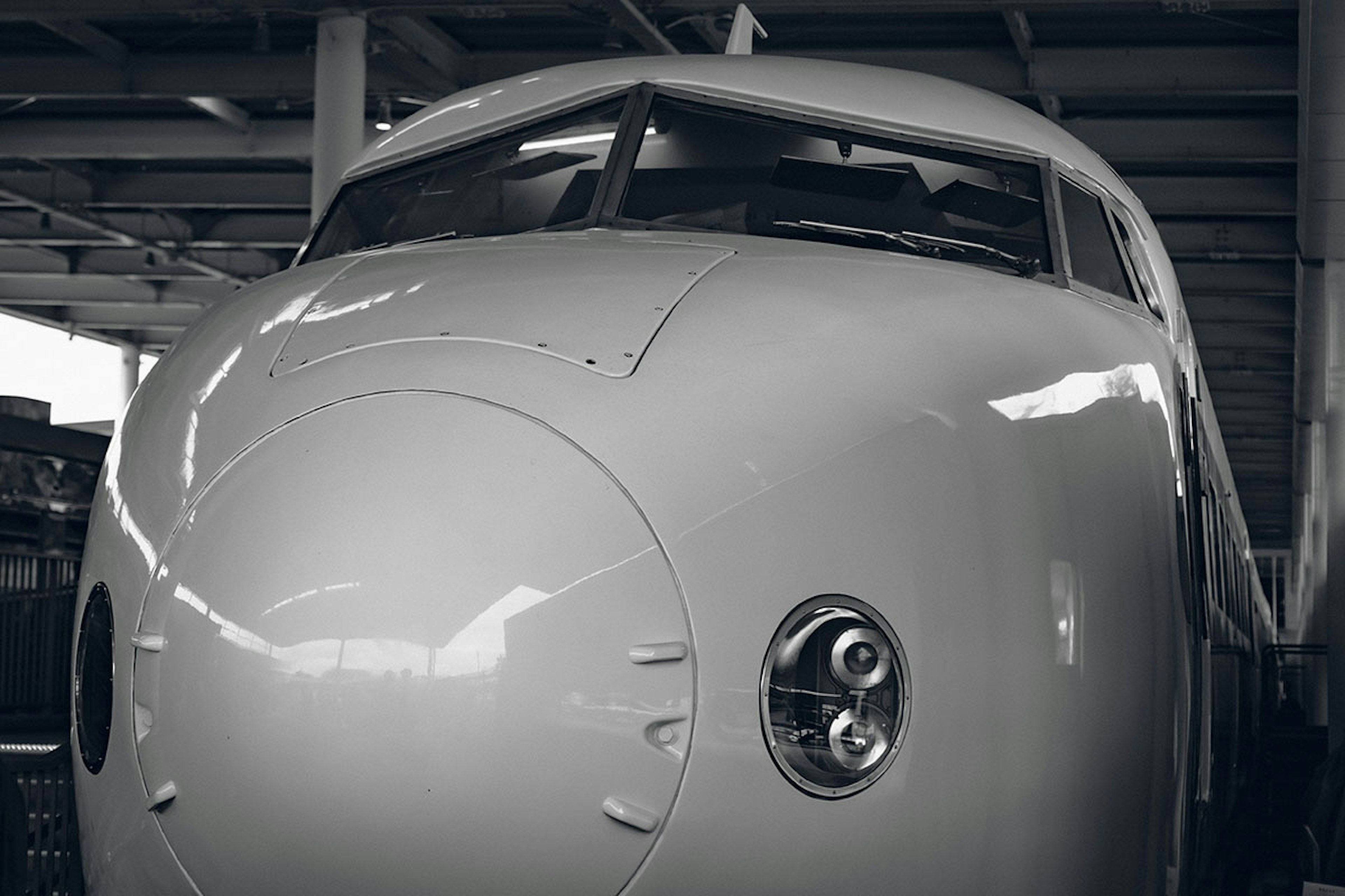 Primer plano de la nariz de un avión de pasajeros blanco que muestra su diseño elegante y grandes ventanales