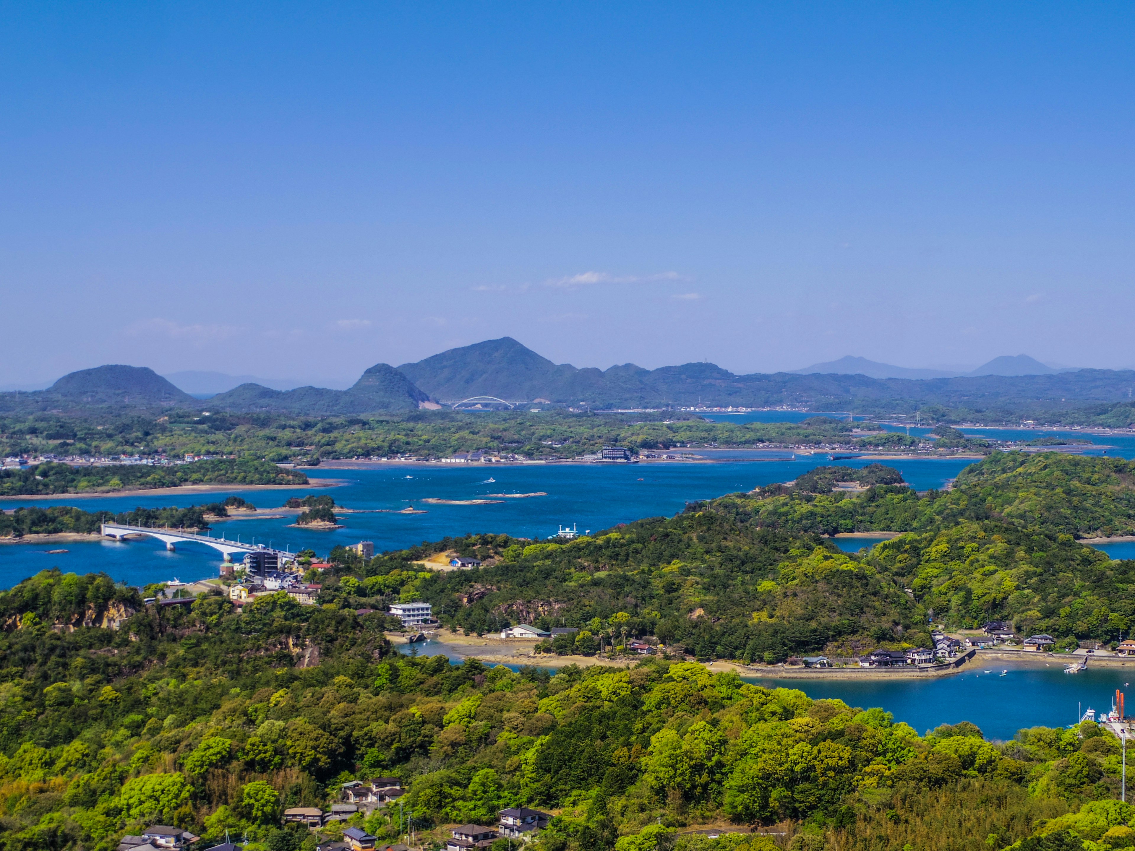 A scenic view of blue waters and lush green hills