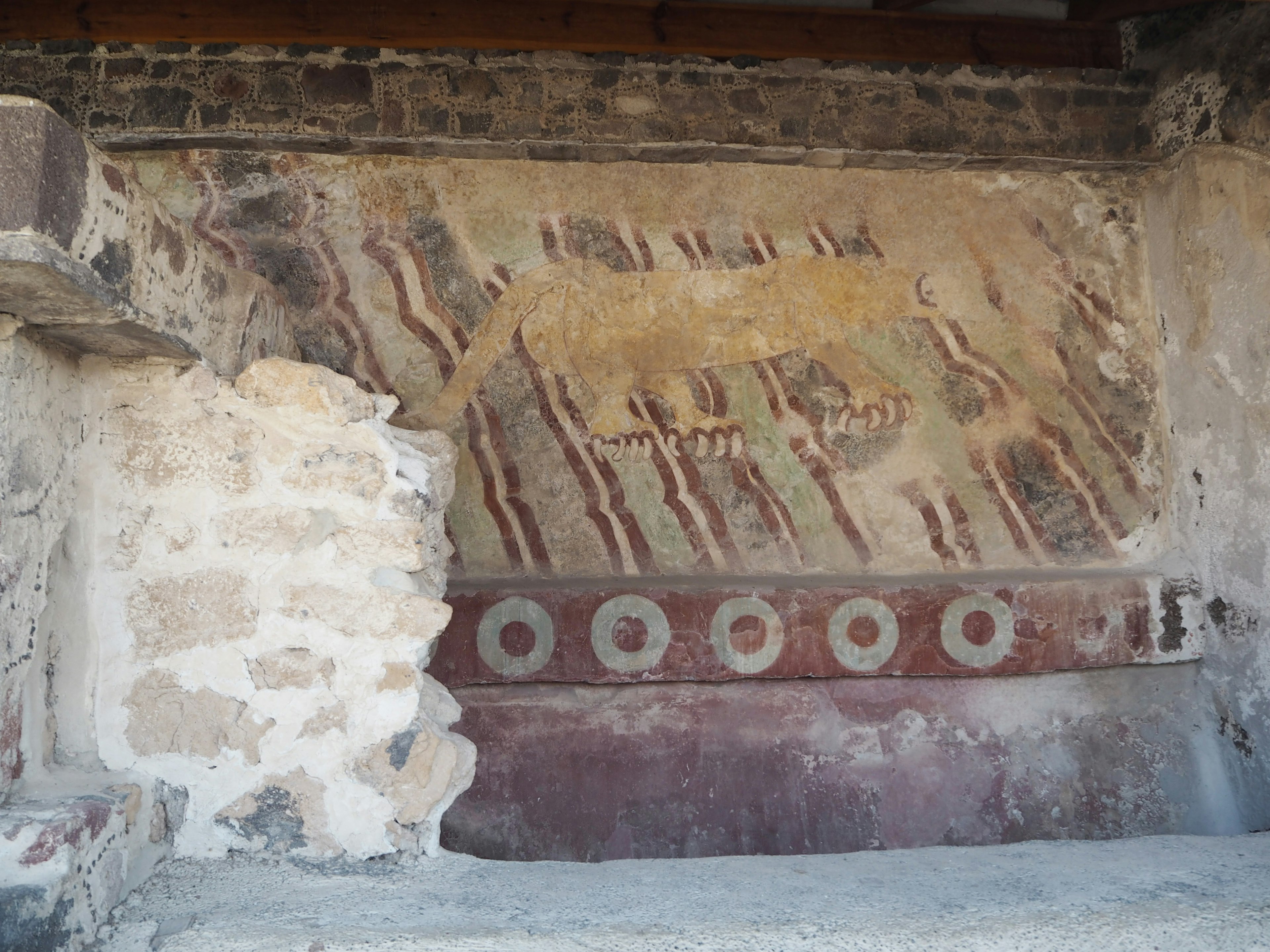 Ancient mural with circular decorations on a stone wall