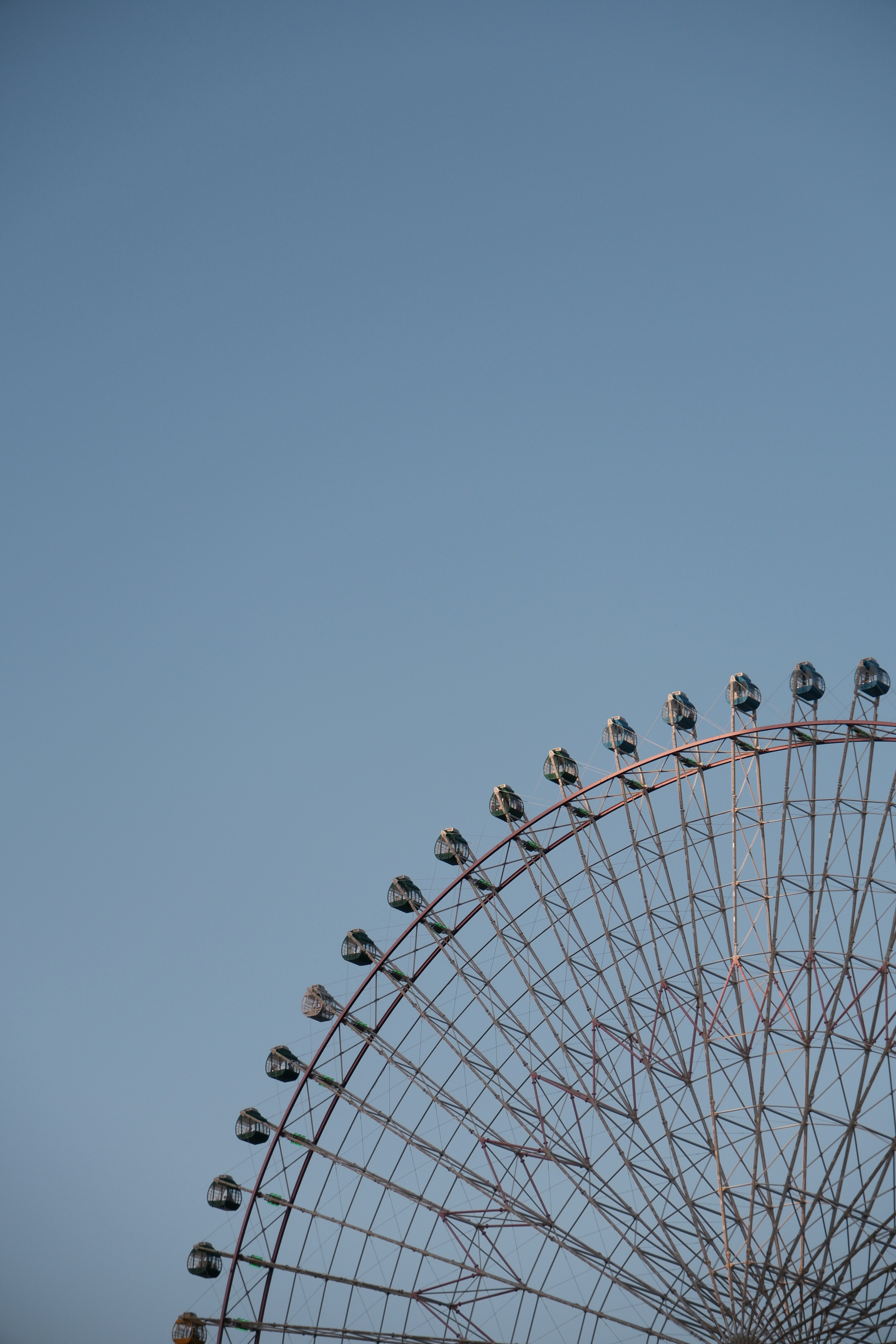 Partie d'une grande roue contre un ciel bleu