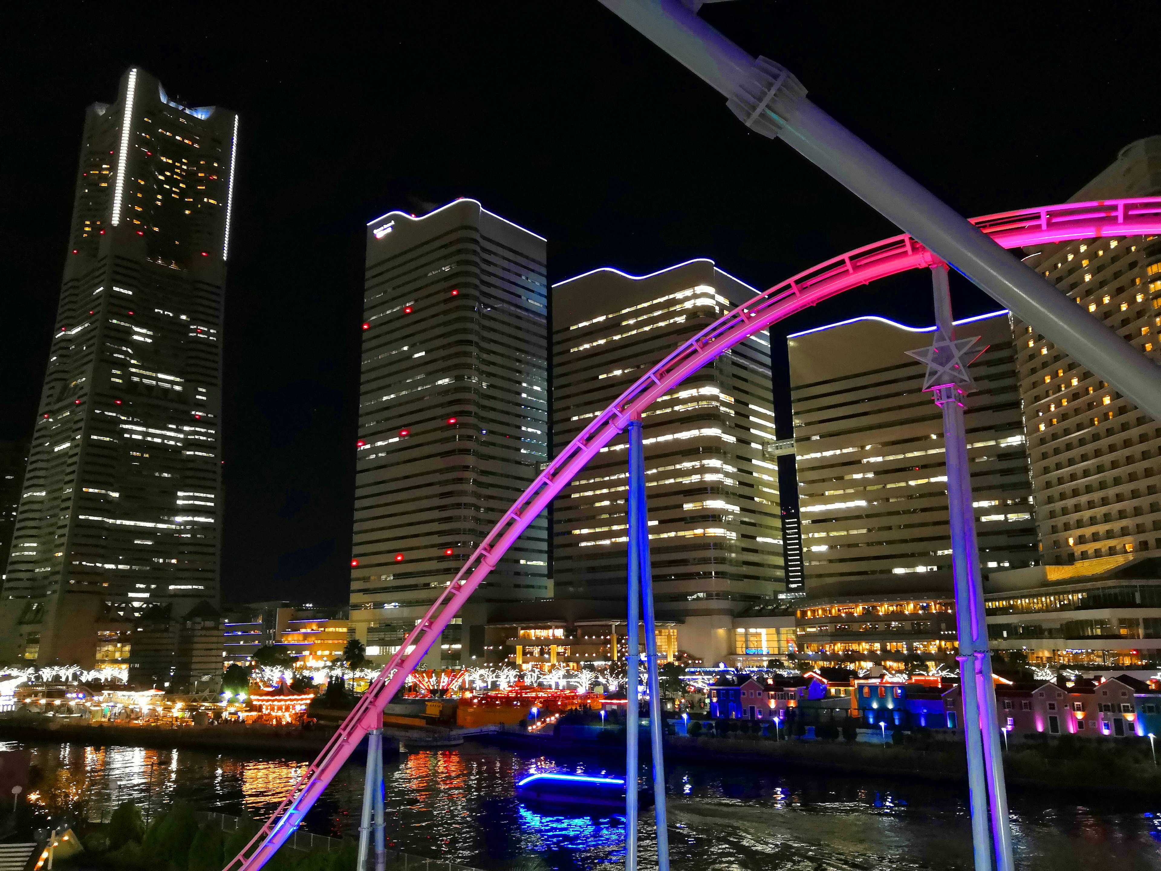 Pemandangan malam cakrawala Yokohama dengan lengkungan roller coaster berwarna