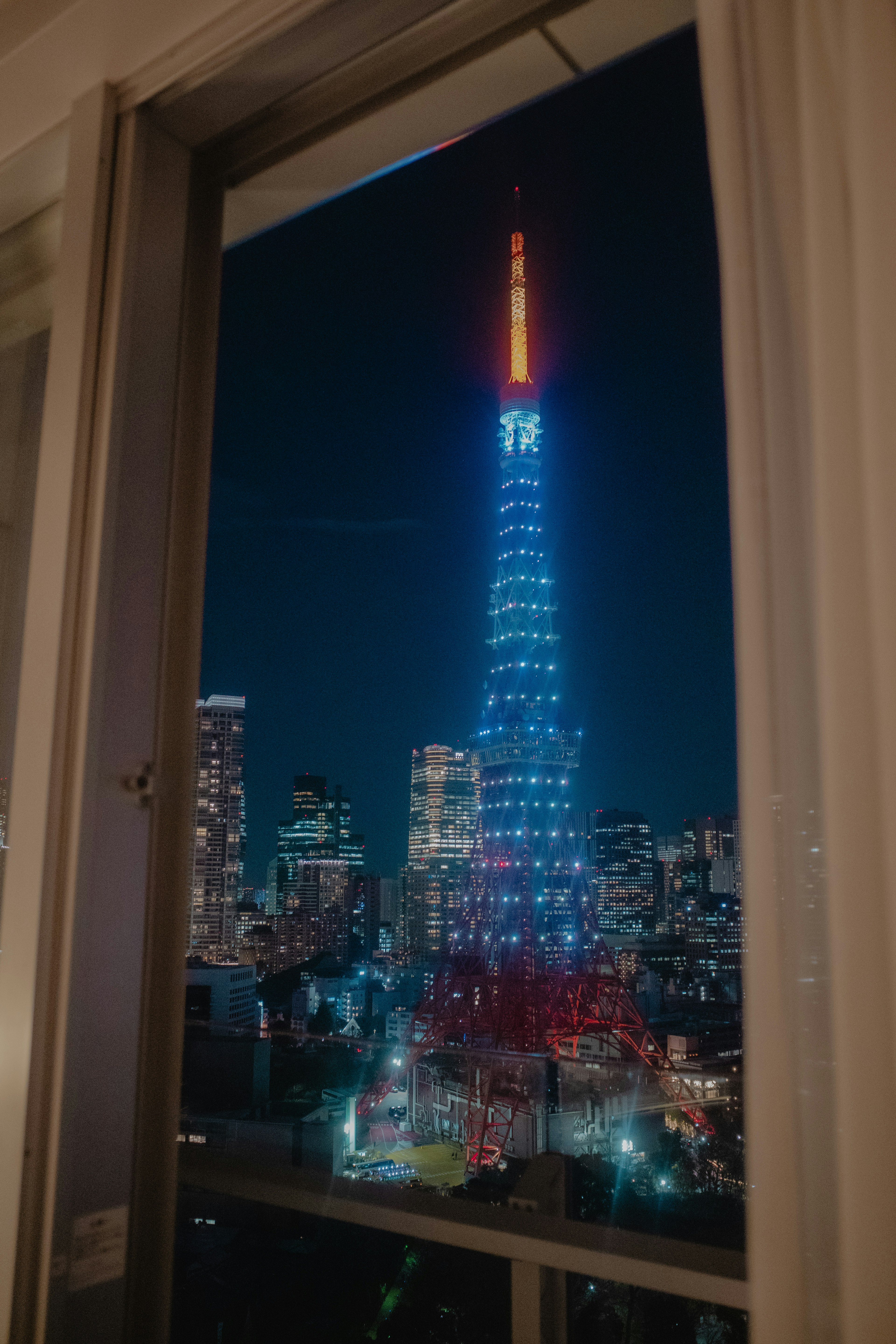 夜の東京タワーの美しいライトアップが窓越しに見える