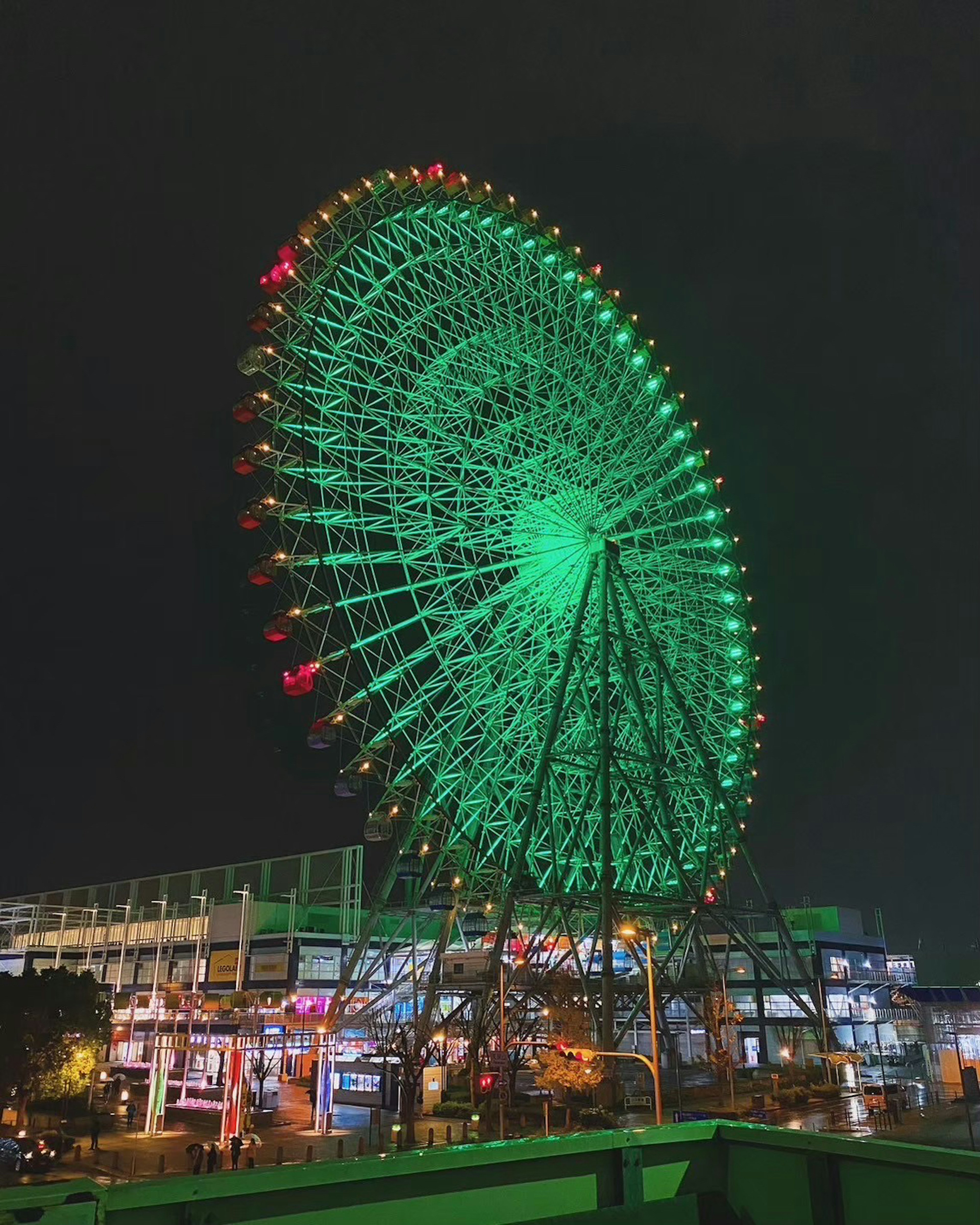 夜に緑色にライトアップされた観覧車の写真