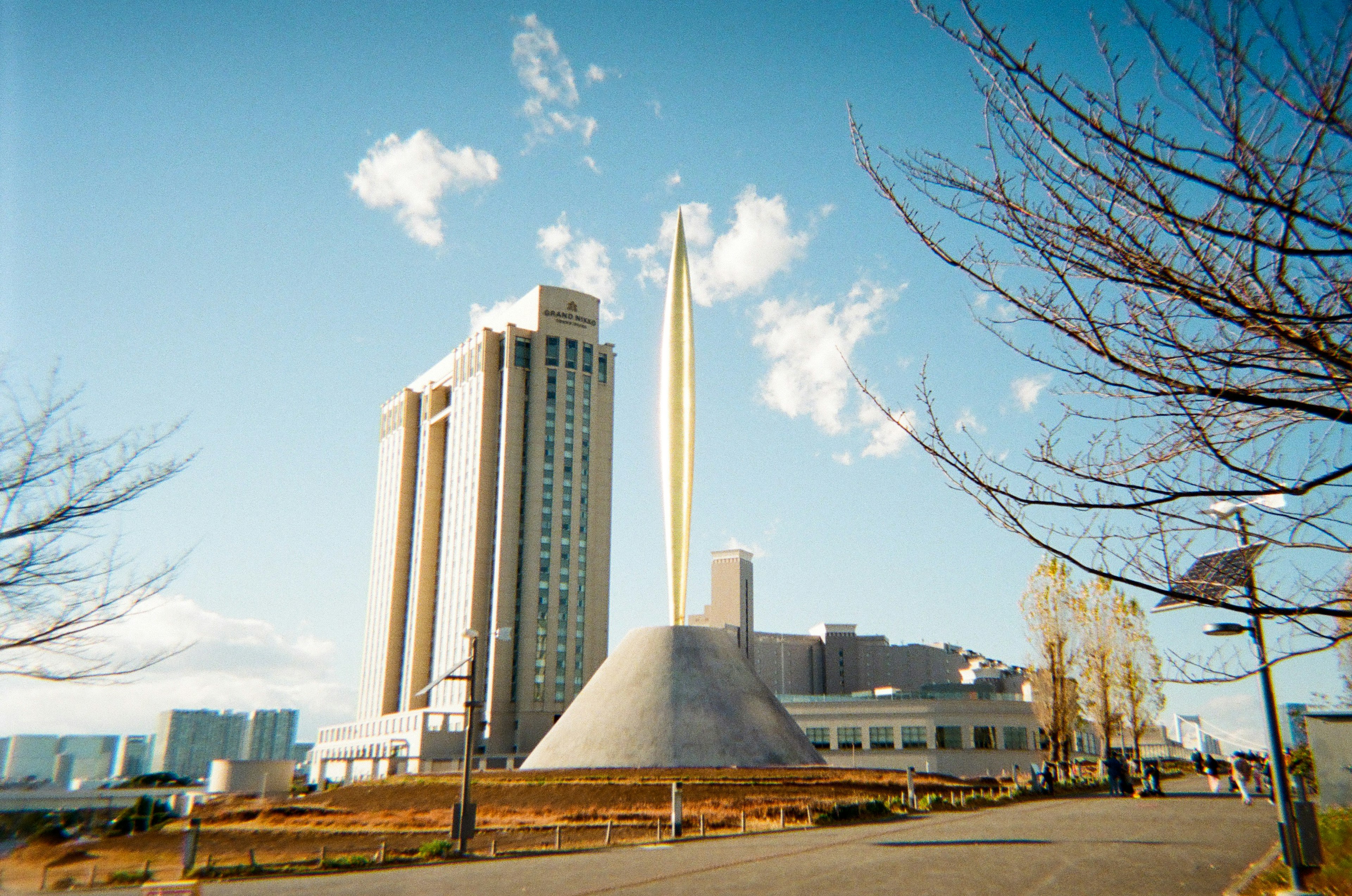 近代的な建物と金色のモニュメントが特徴の風景