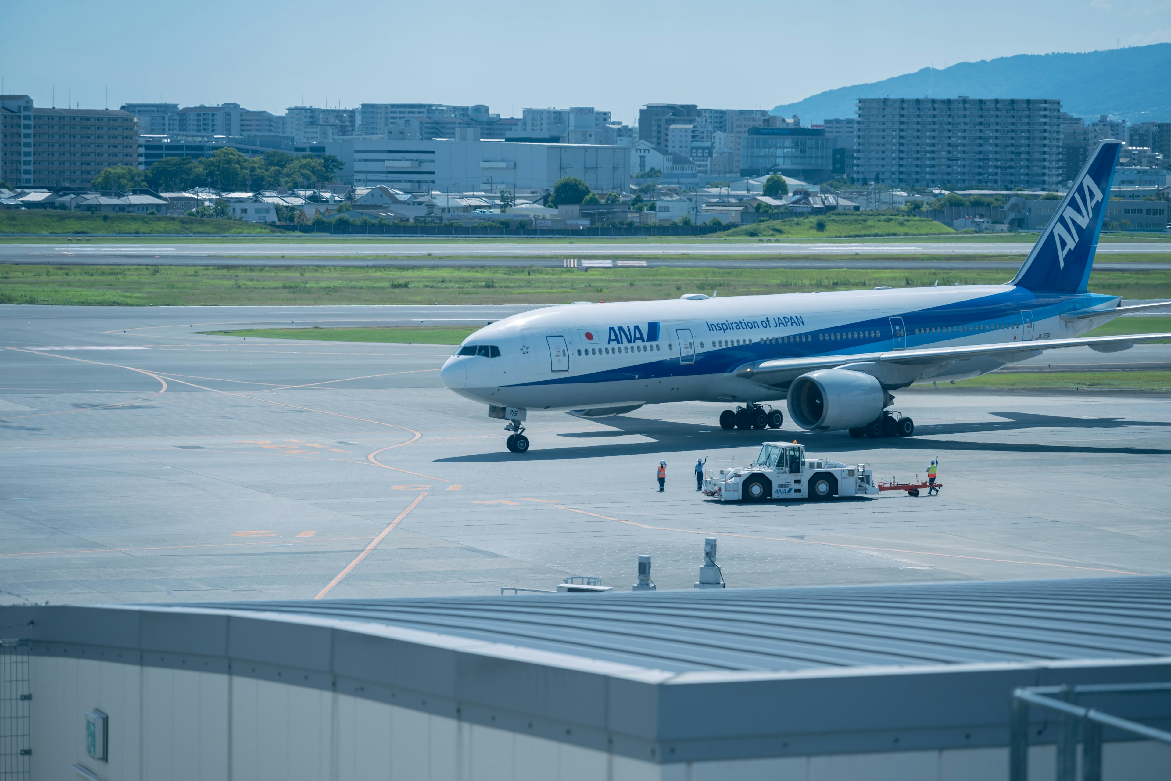 滑走路で待機中のANAの旅客機と地上サービス車両