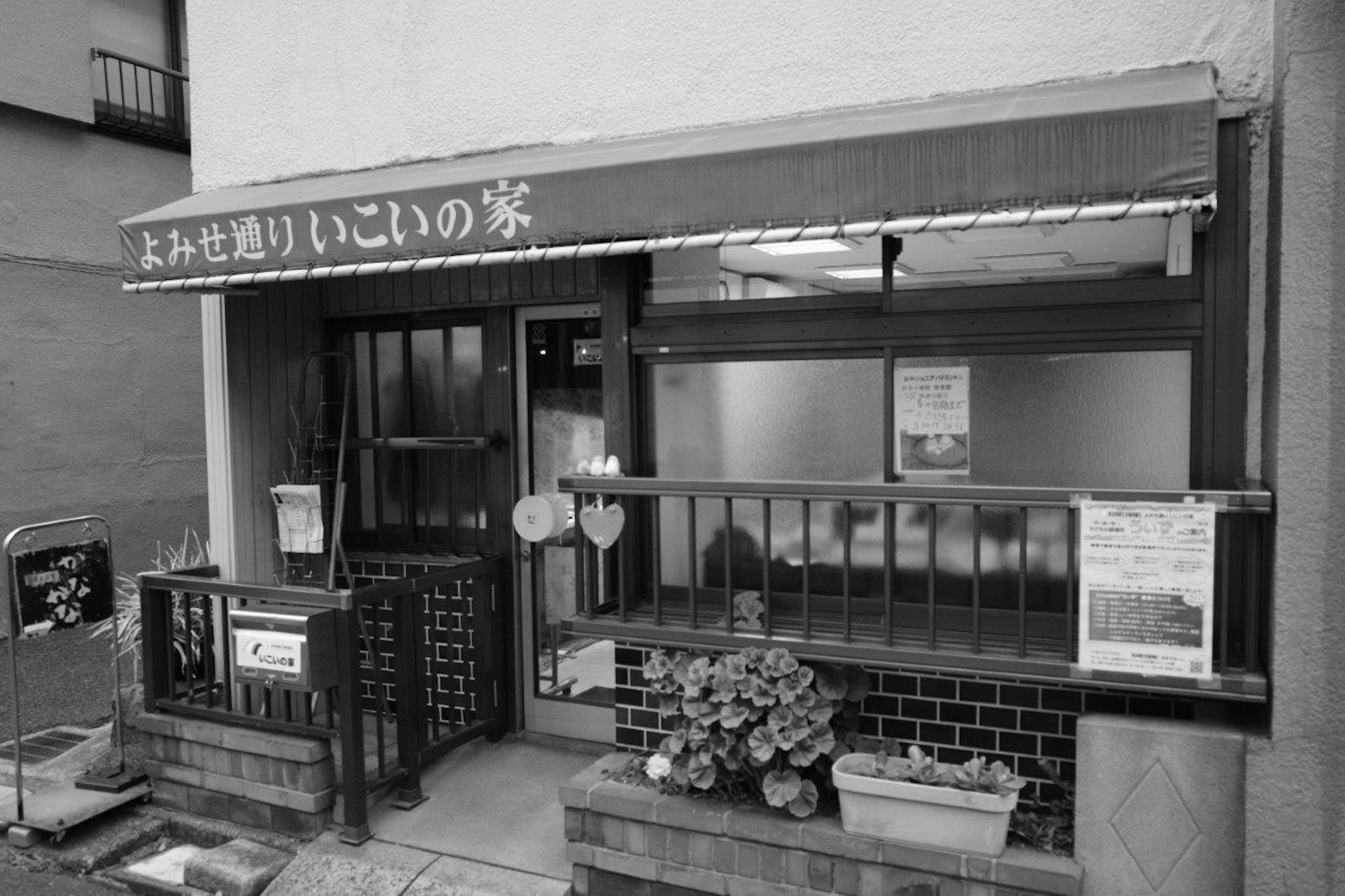 Entrance of a small Japanese restaurant with a black and white exterior