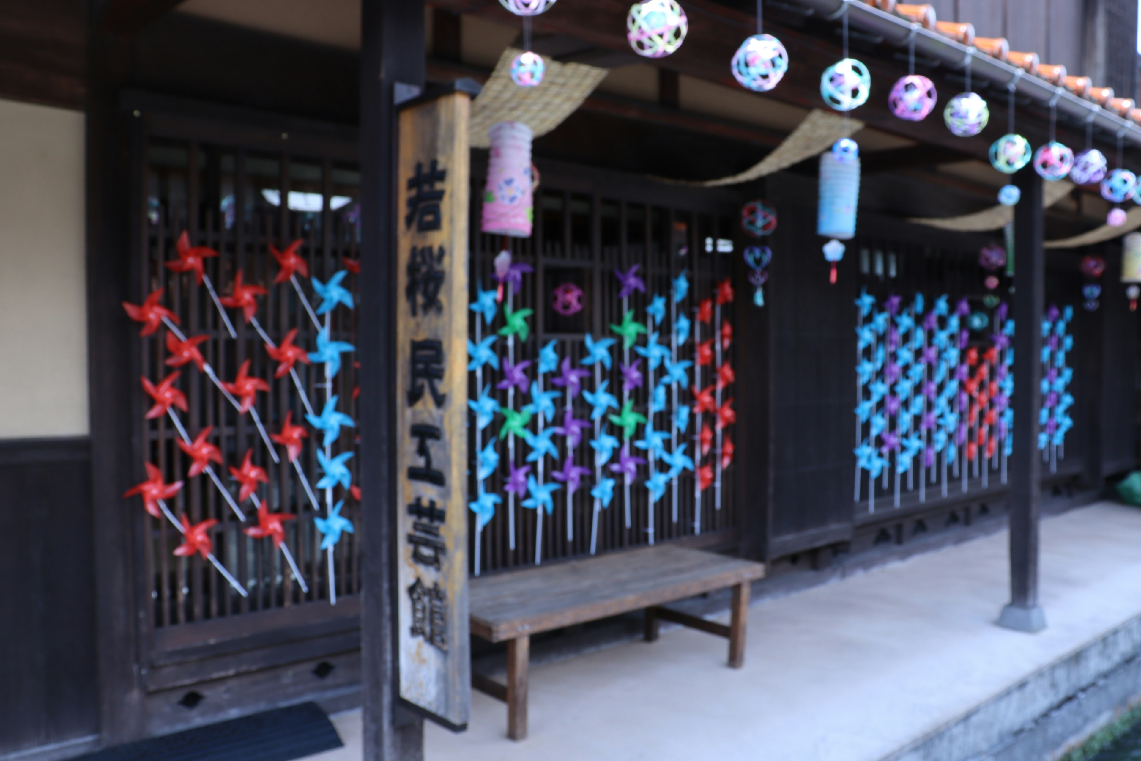 Traditional Japanese building exterior with colorful decorations on windows and sign