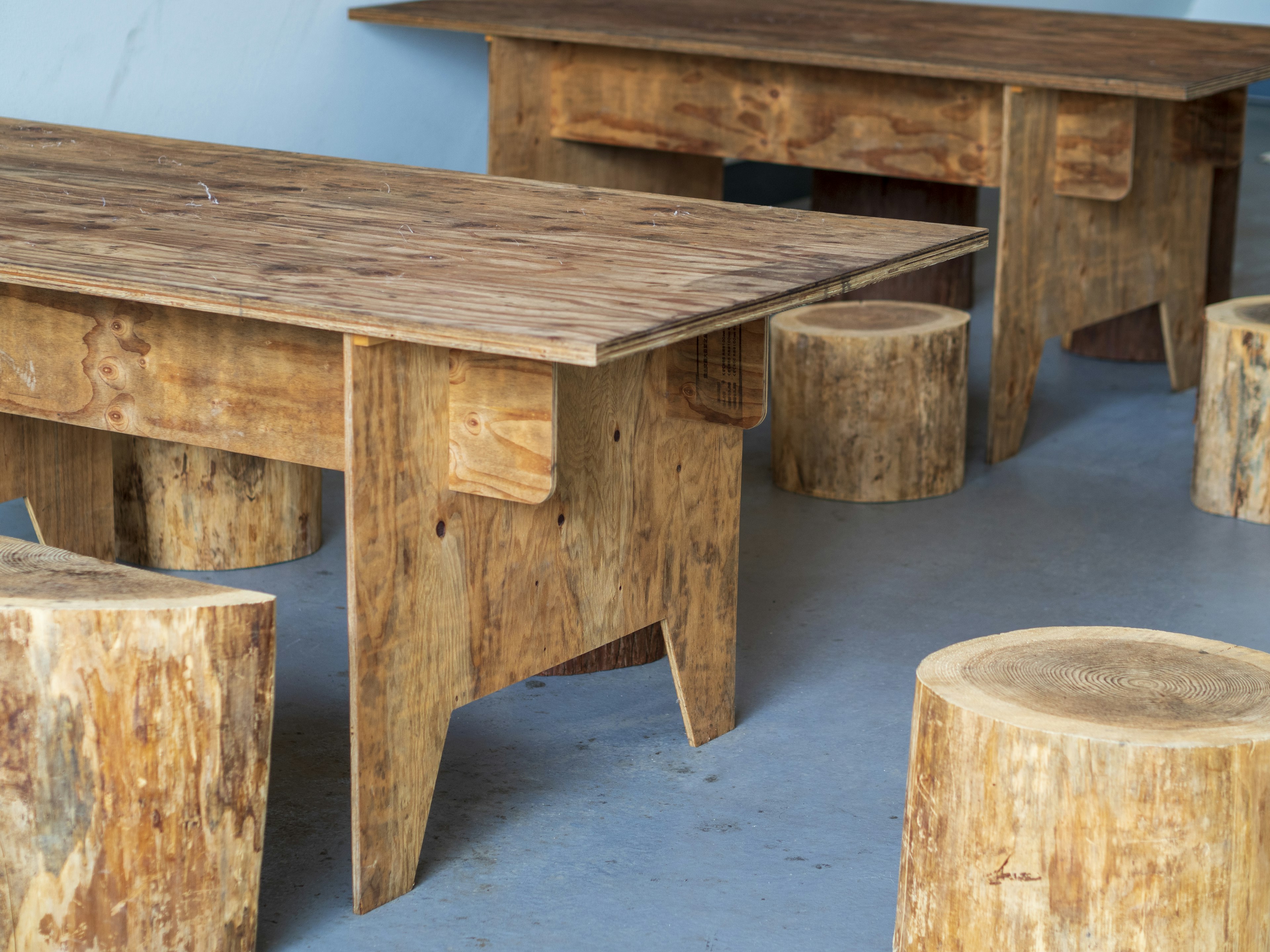 Wooden tables and stools arranged in an interior setting