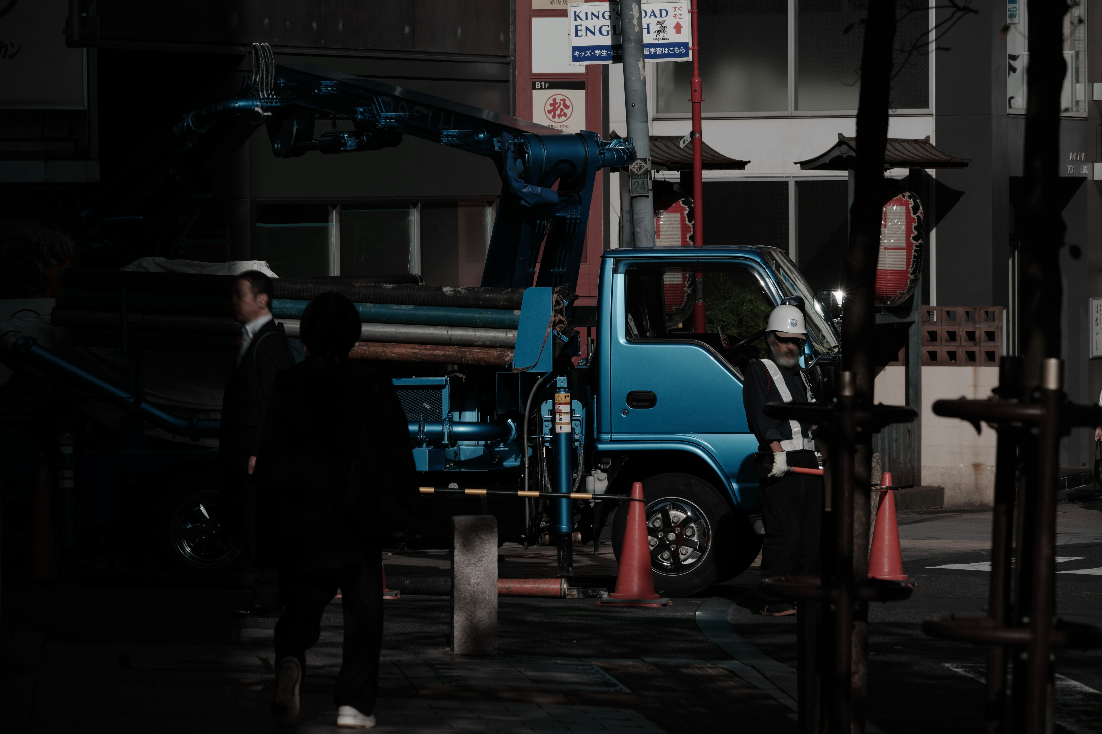 青いトラックと作業員がいる都市の風景