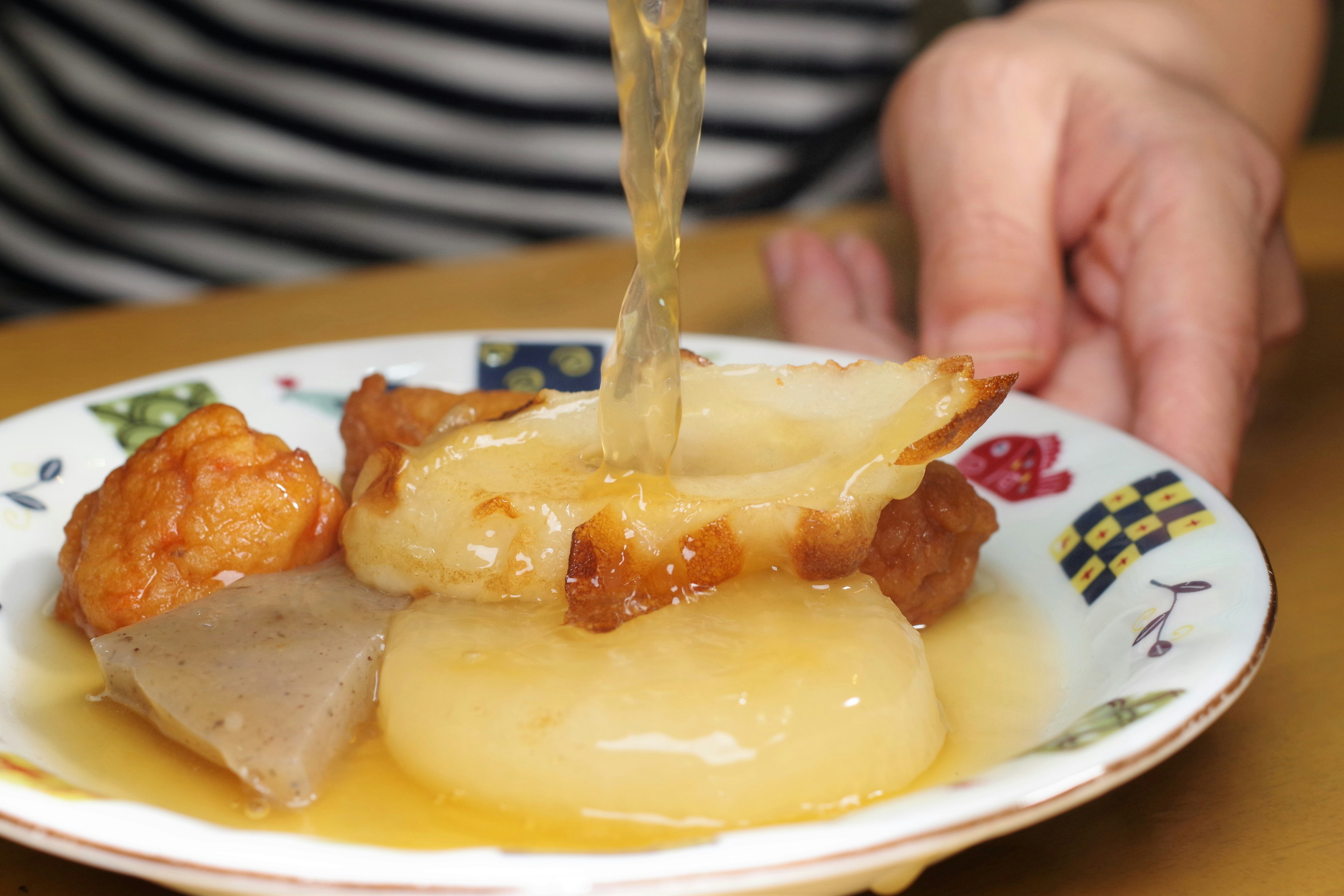 A variety of dishes being served with broth poured over them