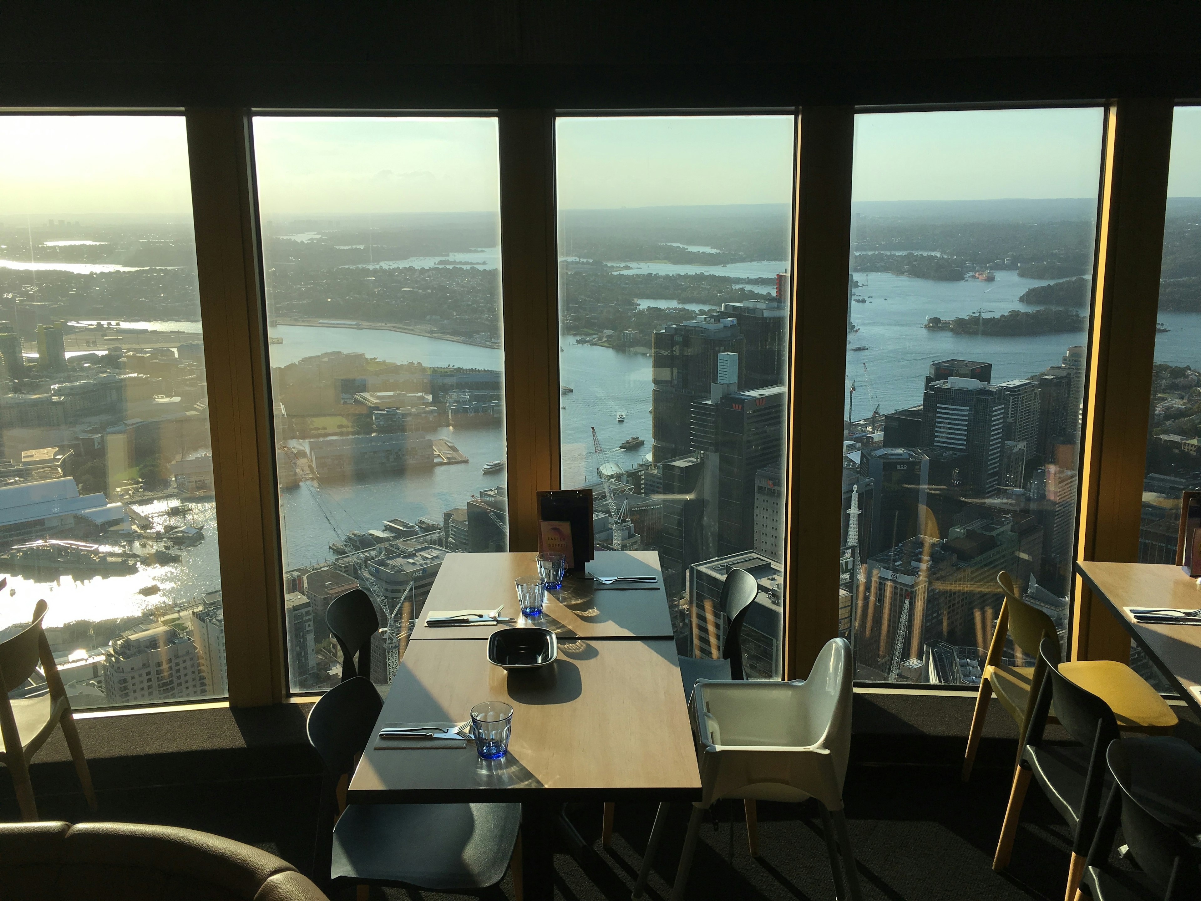 Mesa y sillas en un restaurante con una vista impresionante del horizonte de la ciudad y el agua