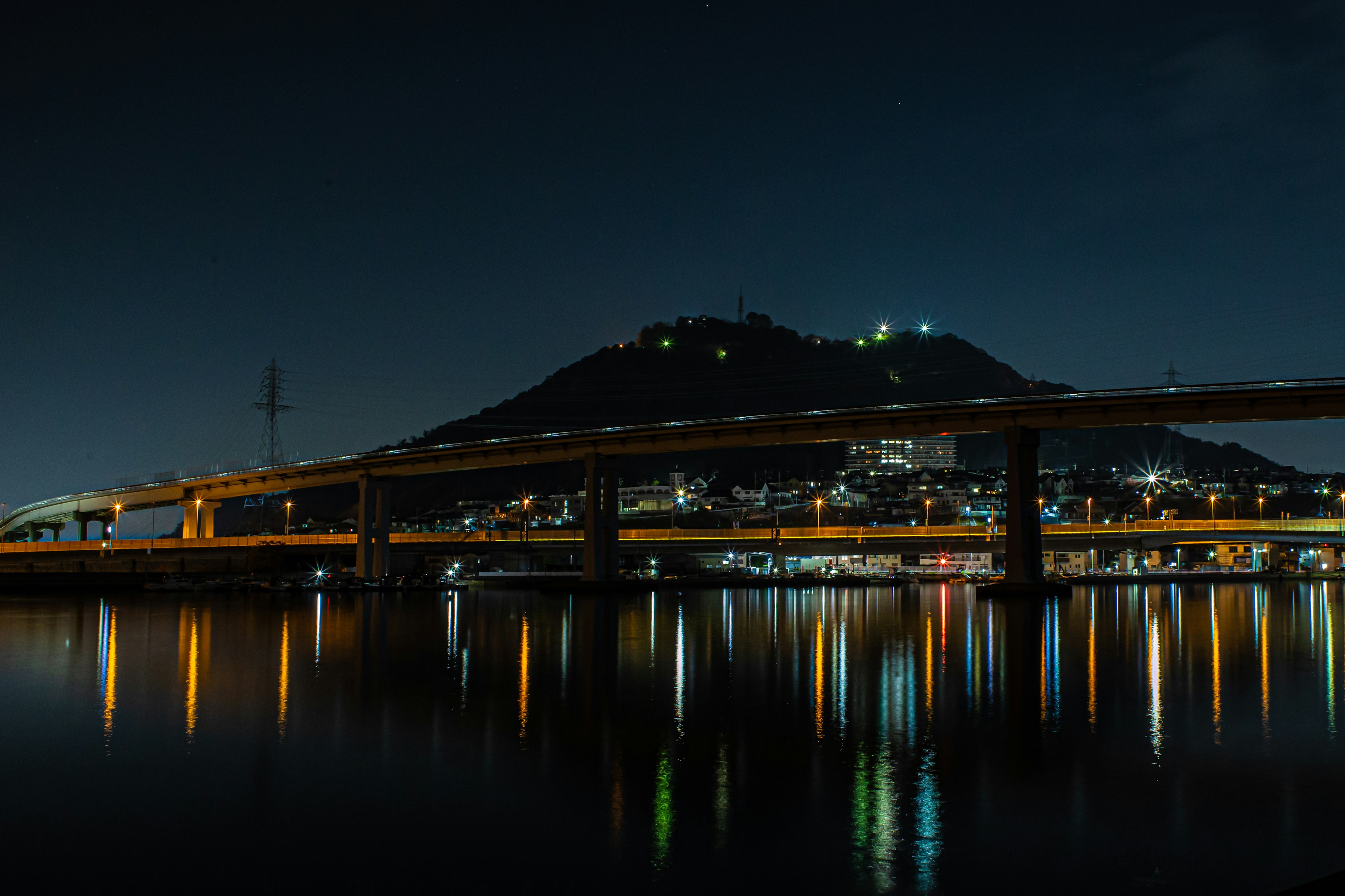 Eine malerische Ansicht eines Flusses und einer nachts beleuchteten Brücke