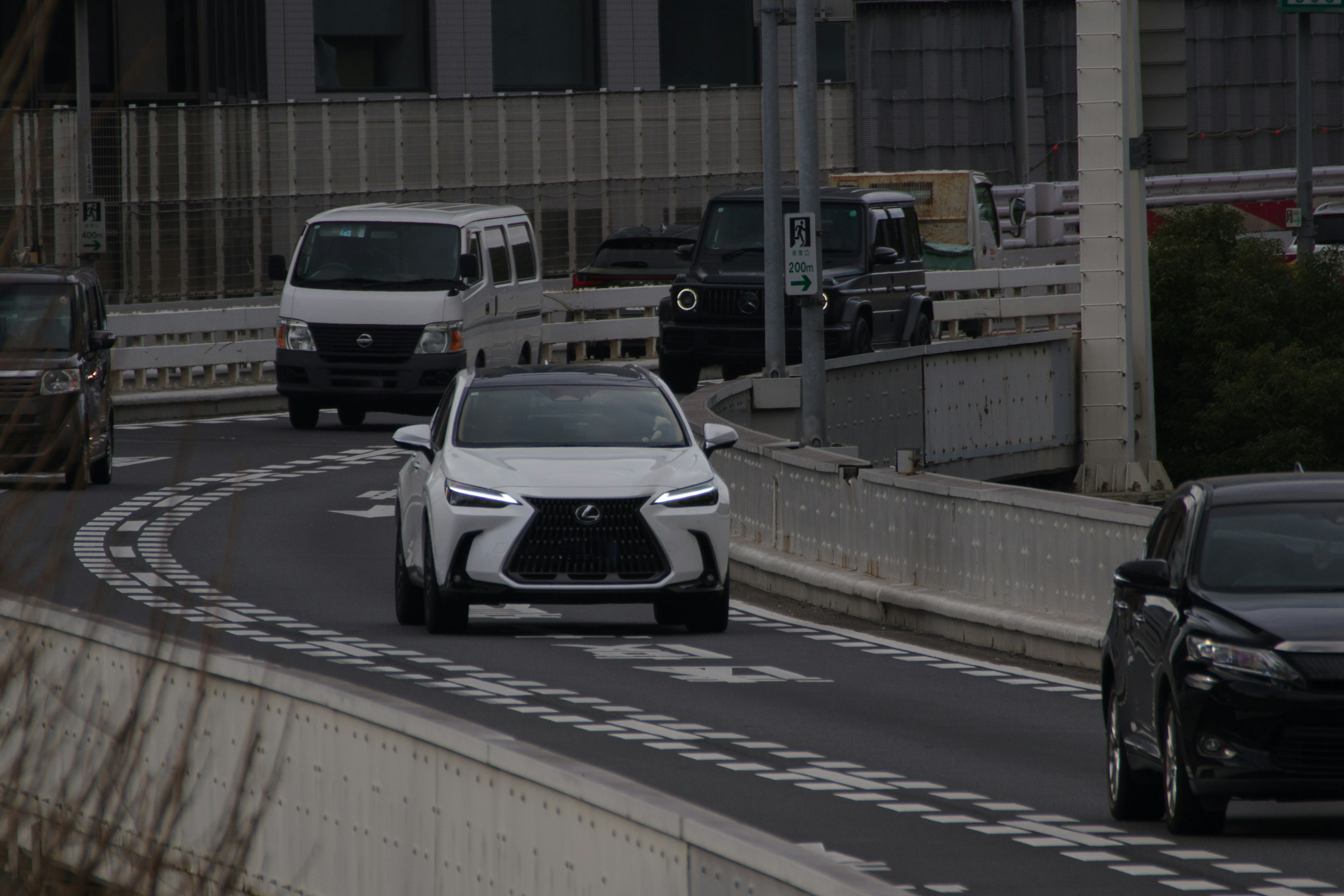 White SUV navigating a winding road with surrounding vehicles