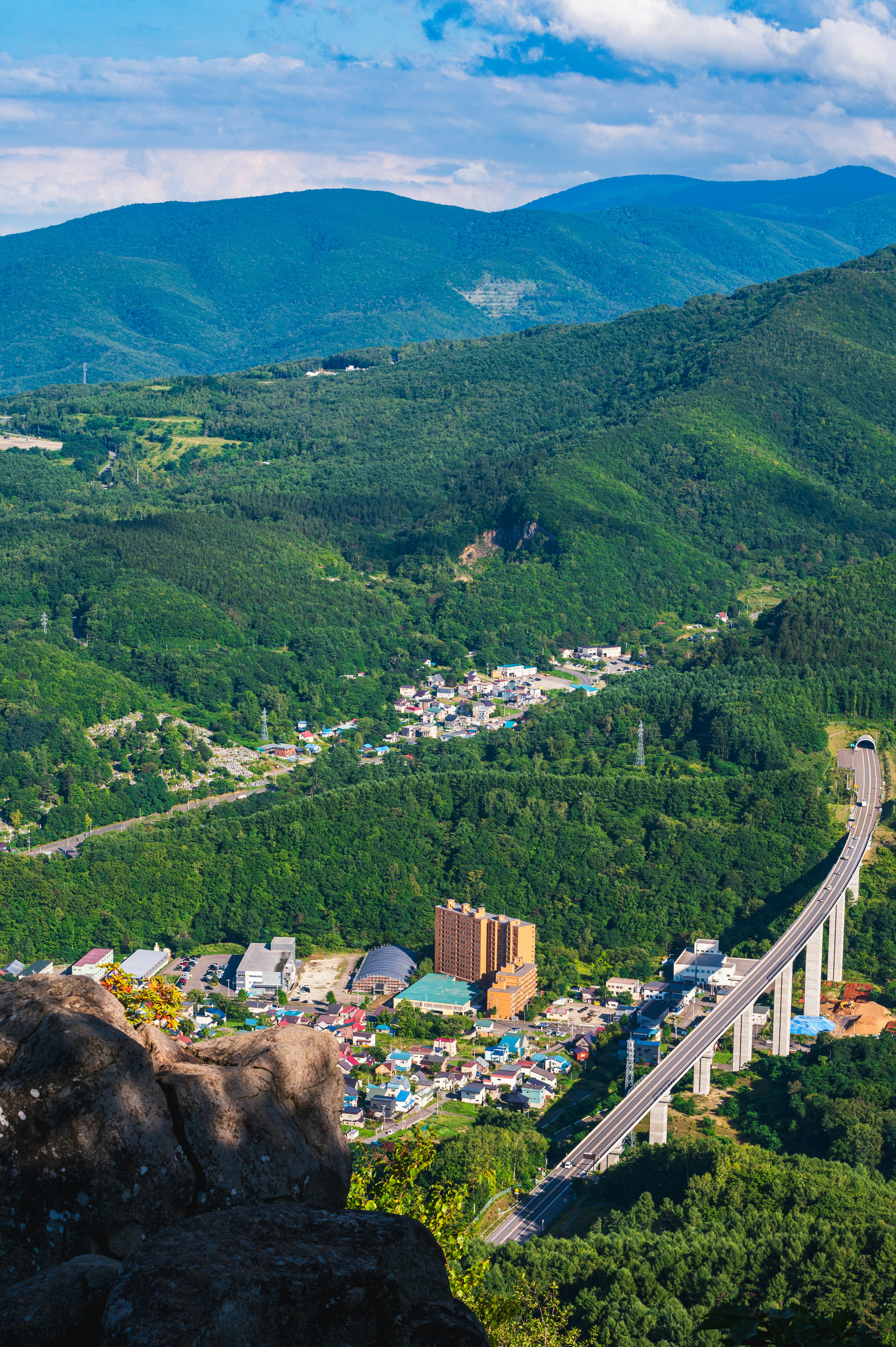 緑豊かな山々と小さな町を背景にした橋の風景