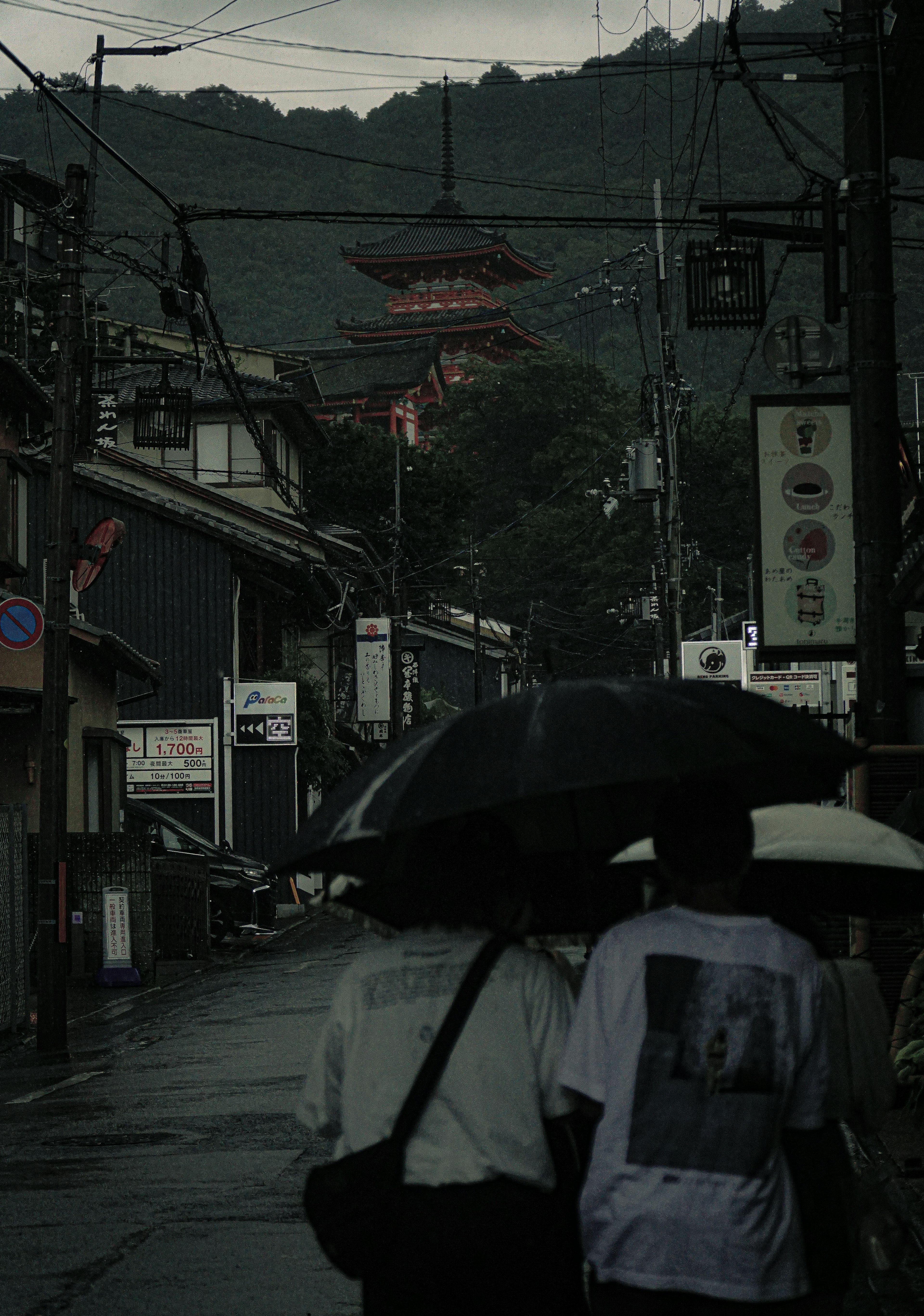 雨の中を歩く人々と伝統的な建物がある静かな街並み