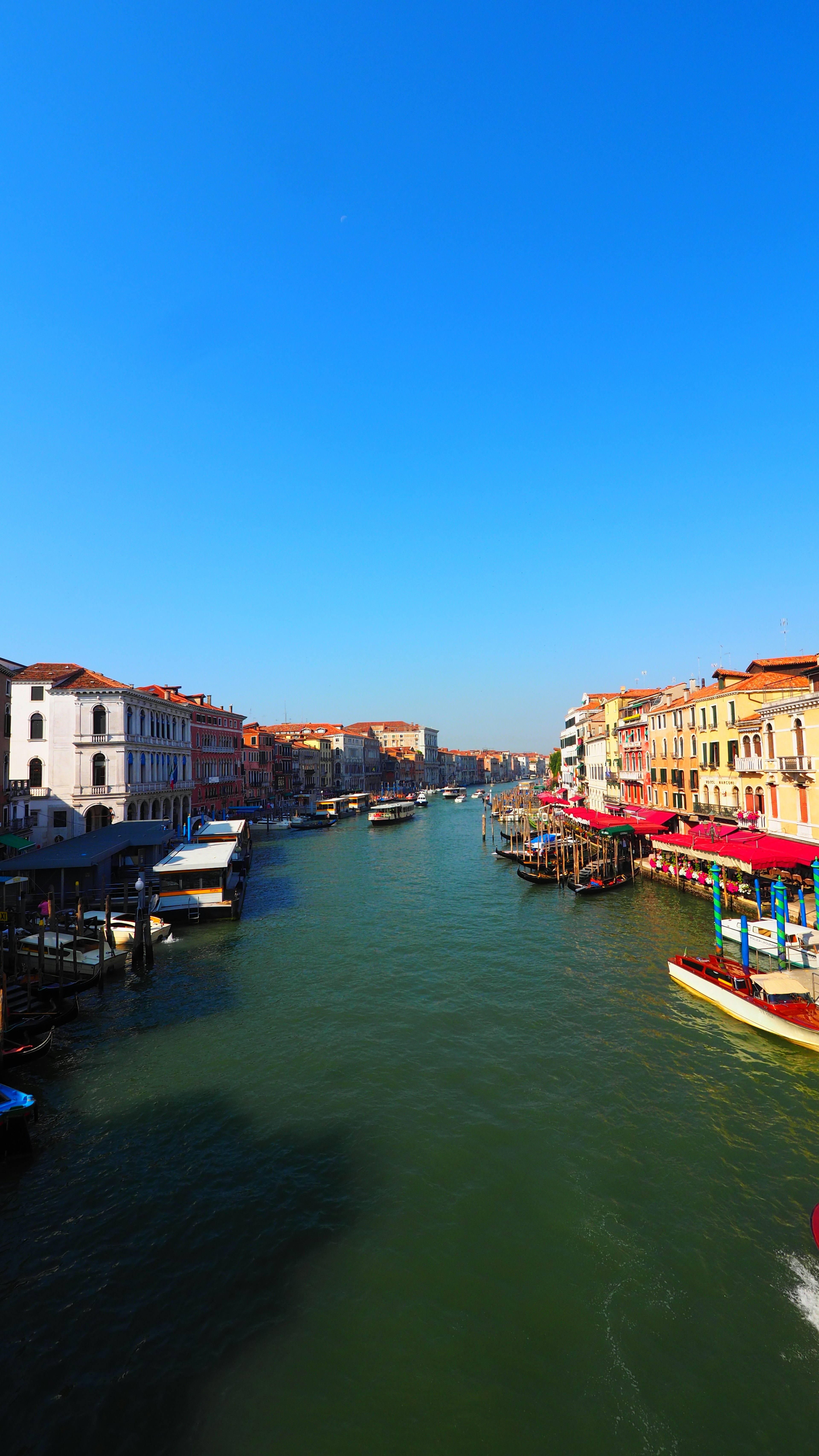 Venetian landscape featuring a canal under a clear blue sky