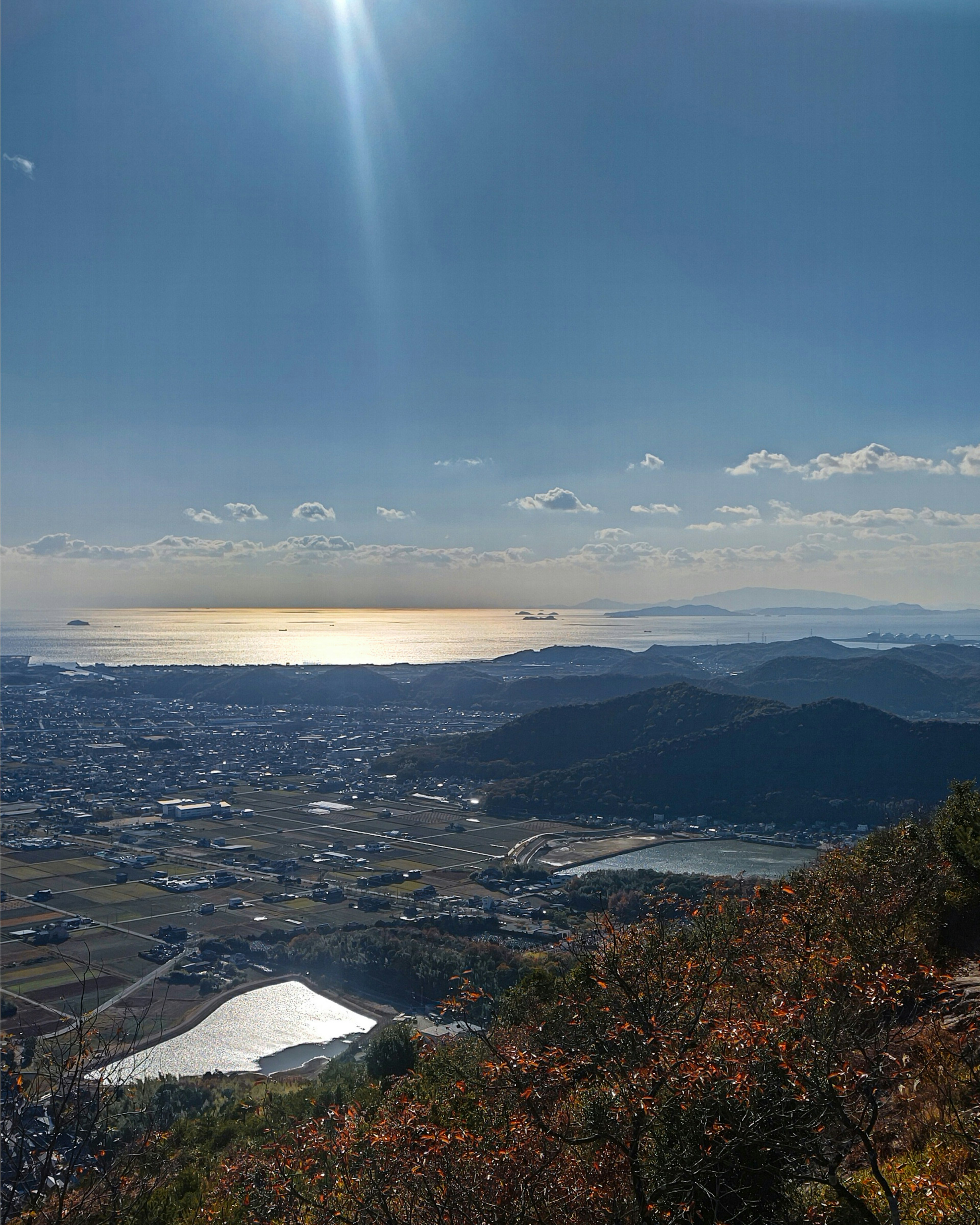 Vista panoramica dalla cima della montagna con riflesso del sole sul mare