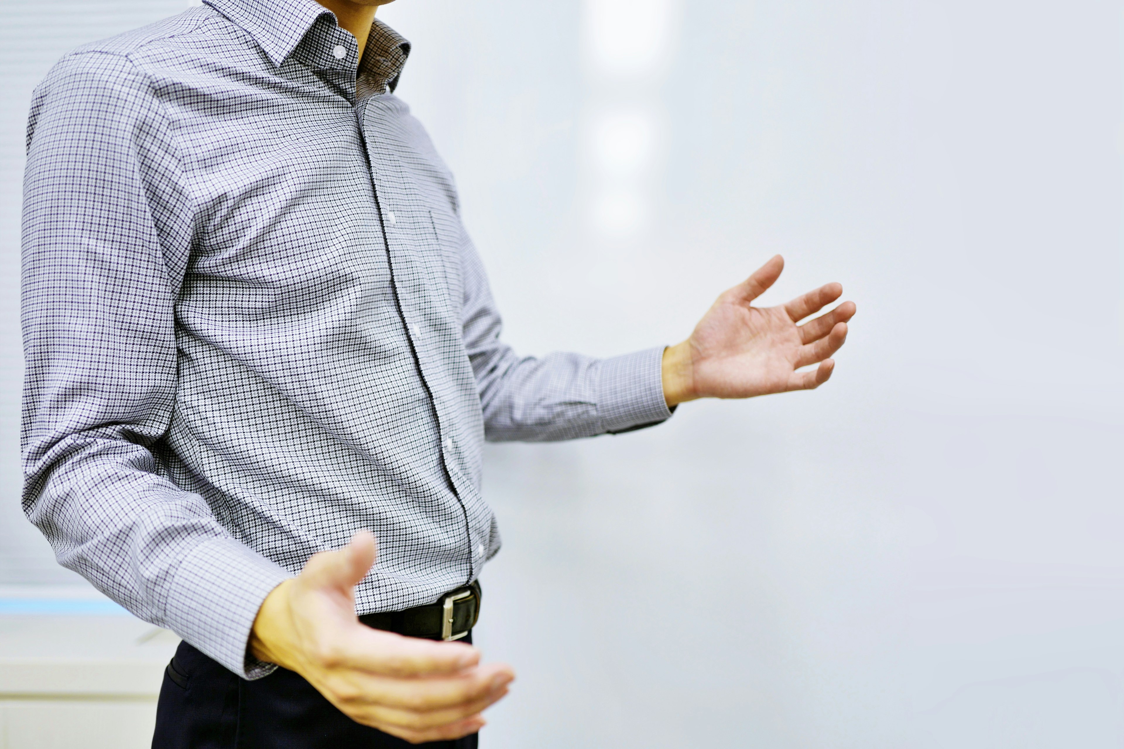 Un uomo in camicia elegante che gesticola con le mani aperte