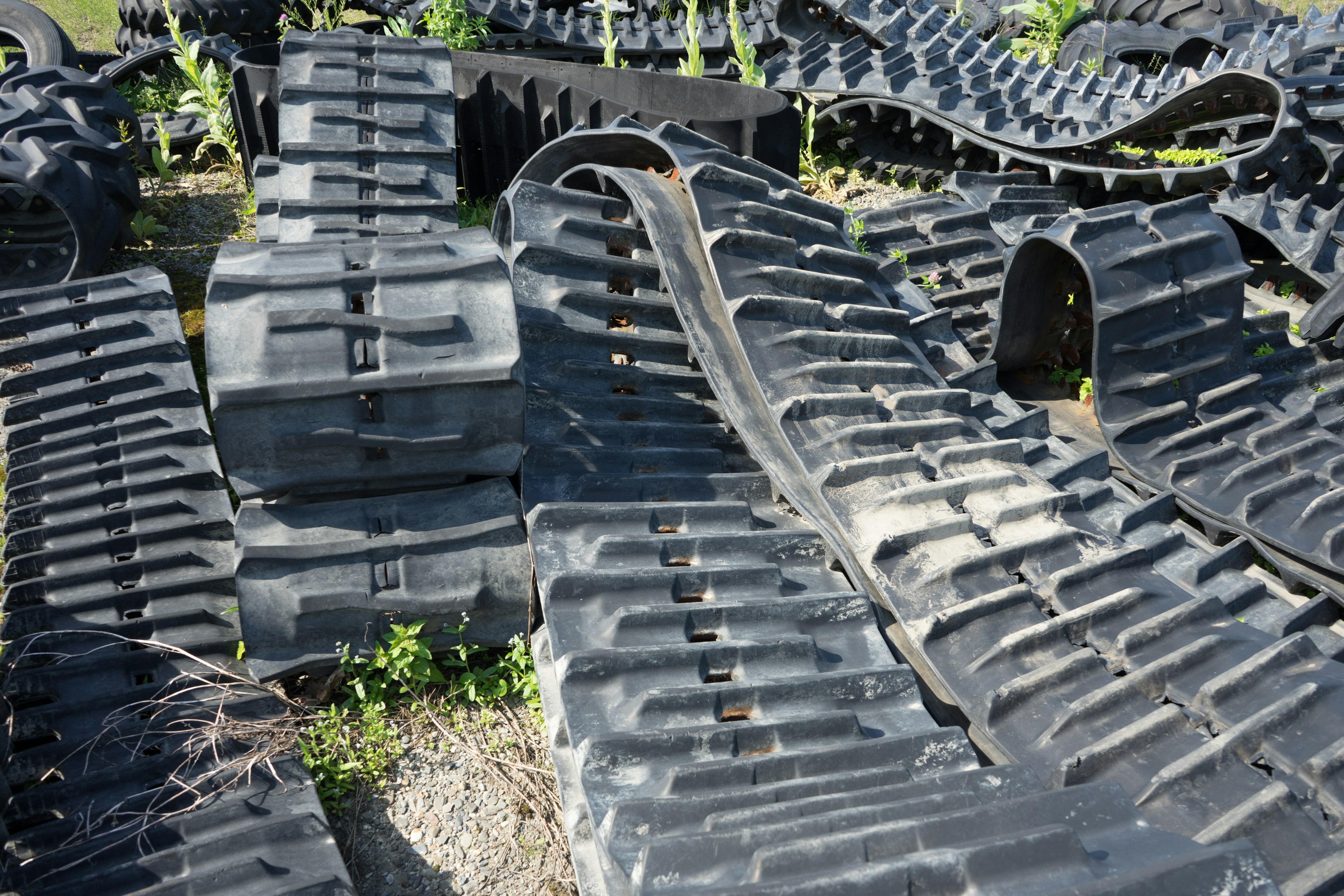 Landscape of stacked black tracks with grass growing around them