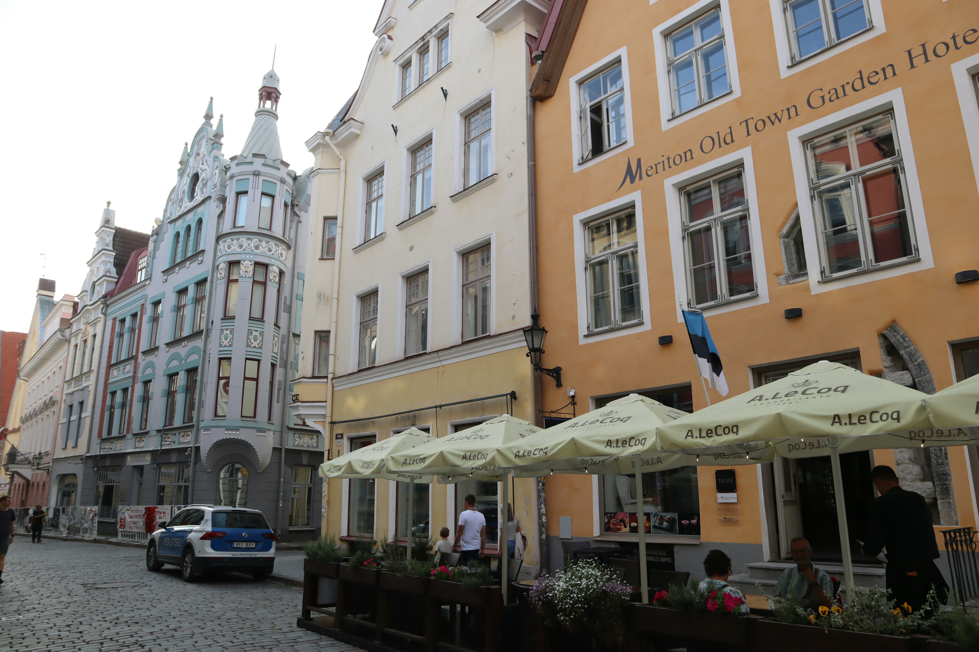 Calle histórica en Tallin con edificios coloridos y una terraza de café