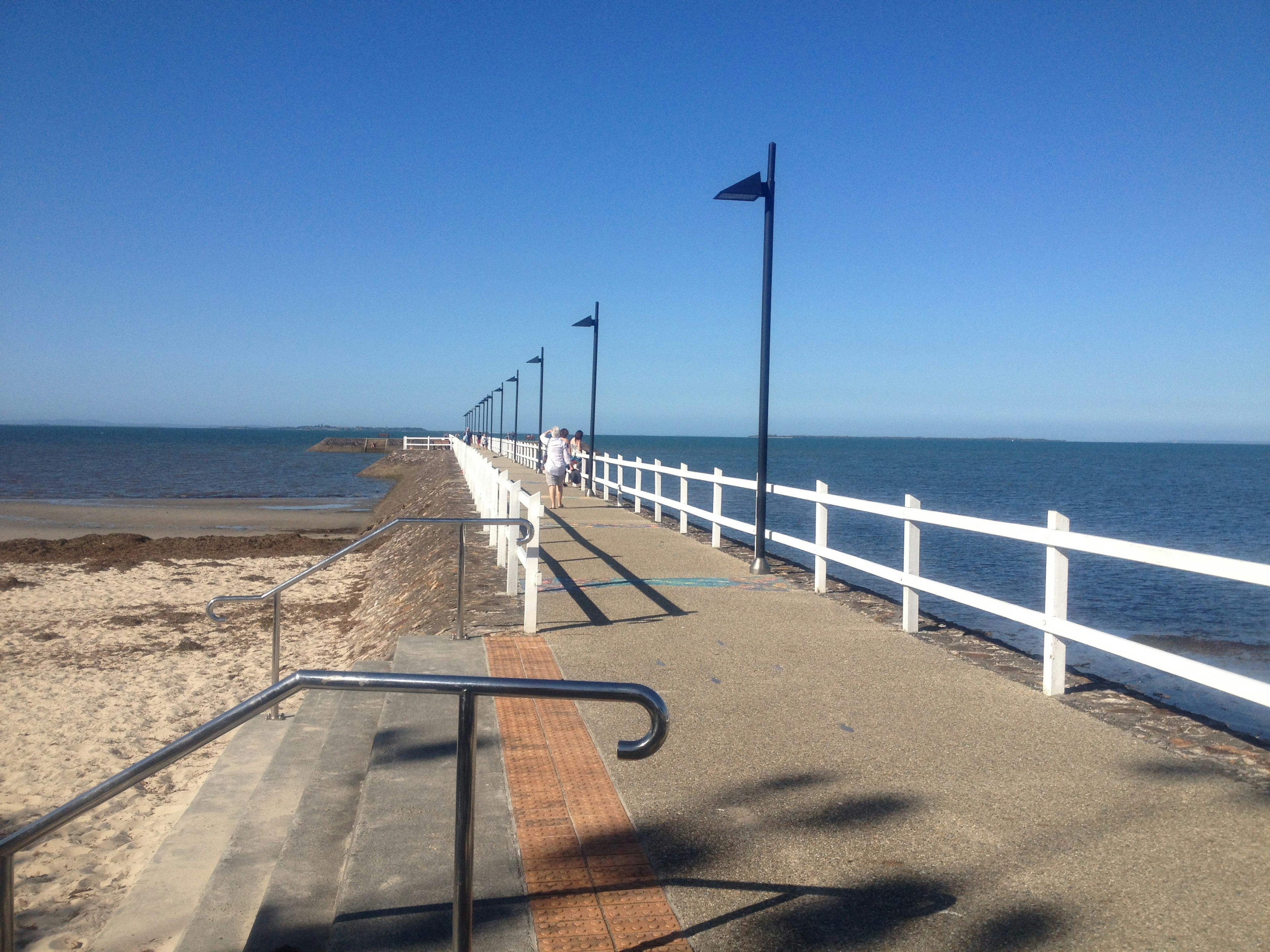 Scenic view of a pier with white railings and blue ocean