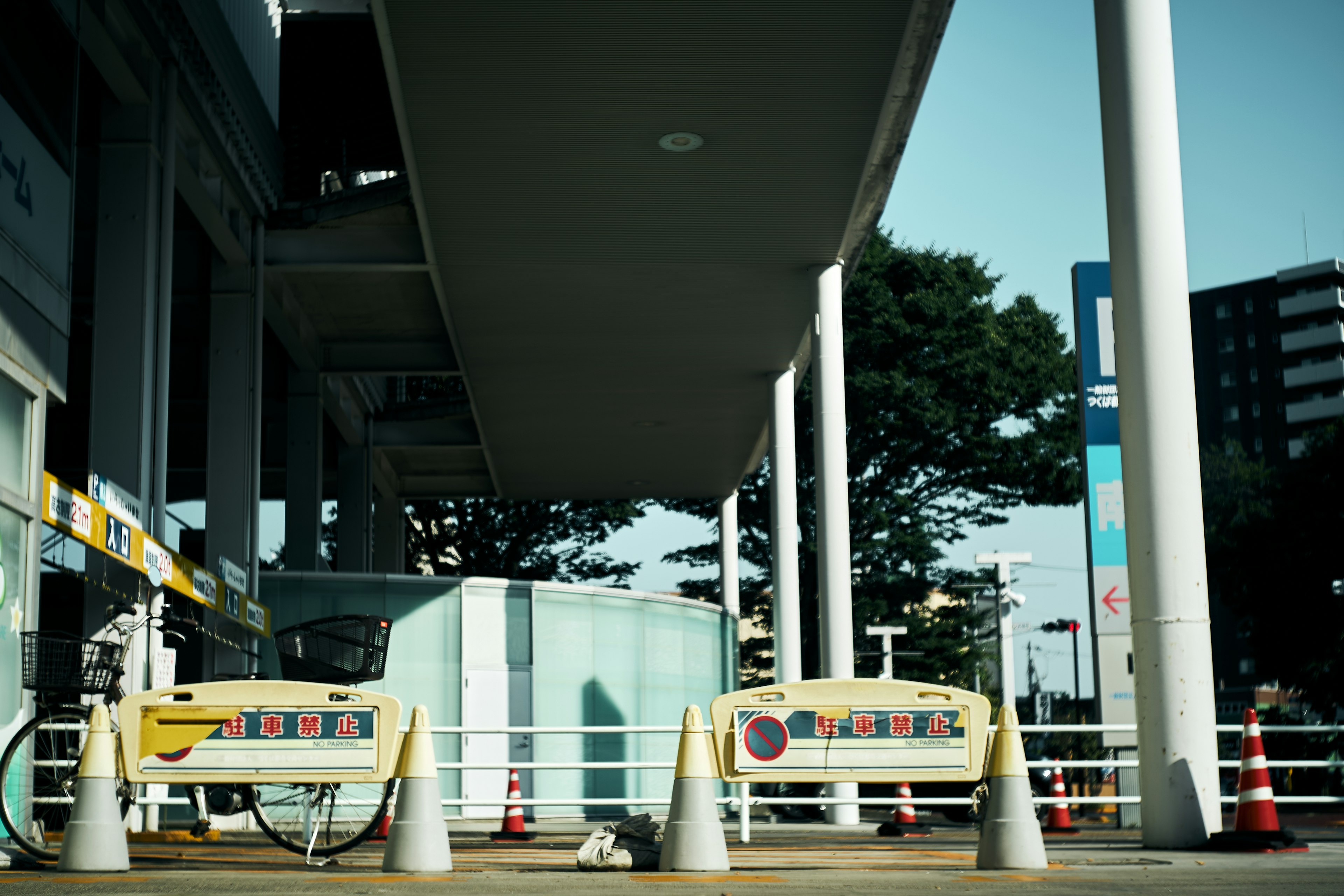 明るい青空の下にあるガソリンスタンドの入り口と白いコーン