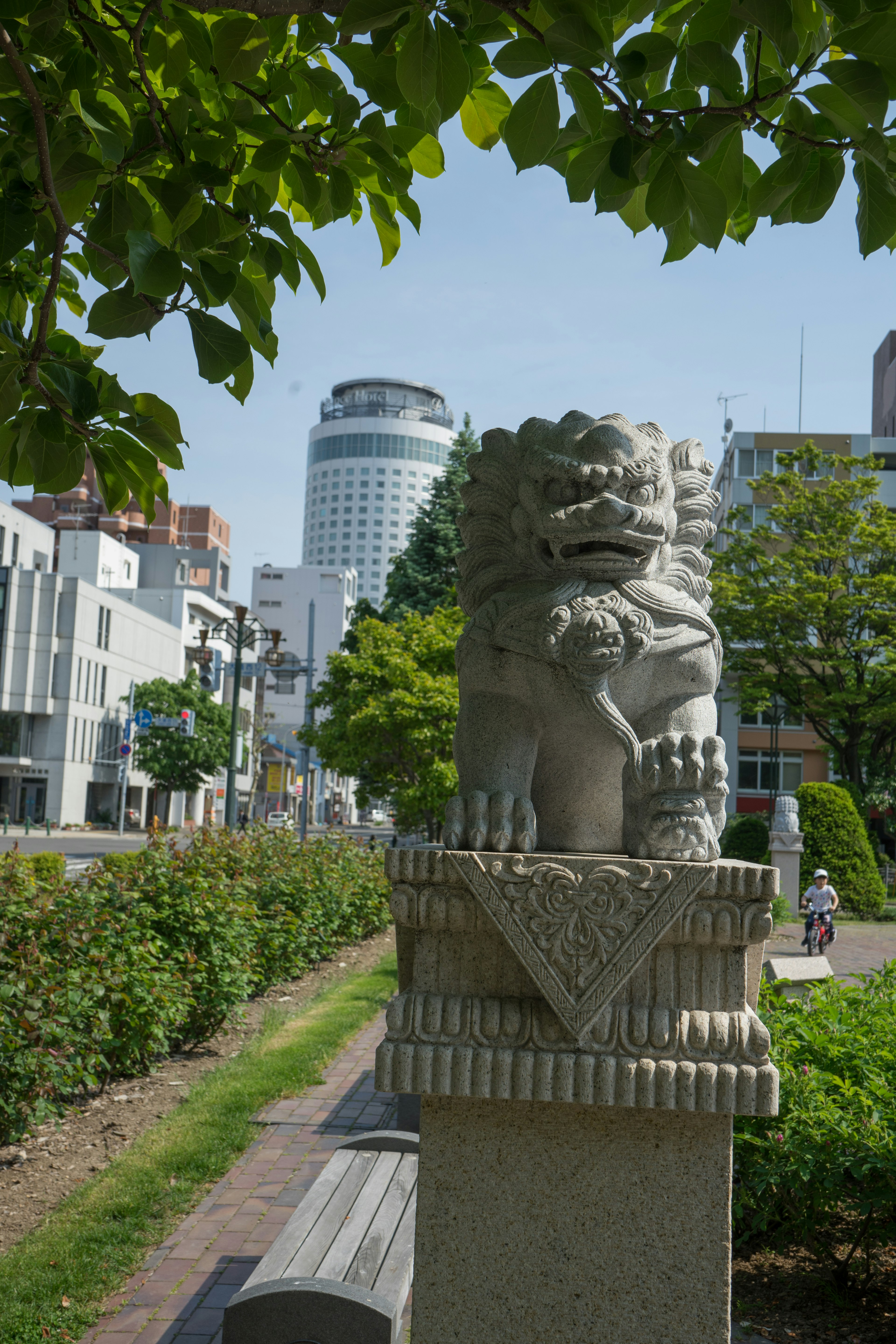 公園裡的石獅子雕像和背景中的現代建築