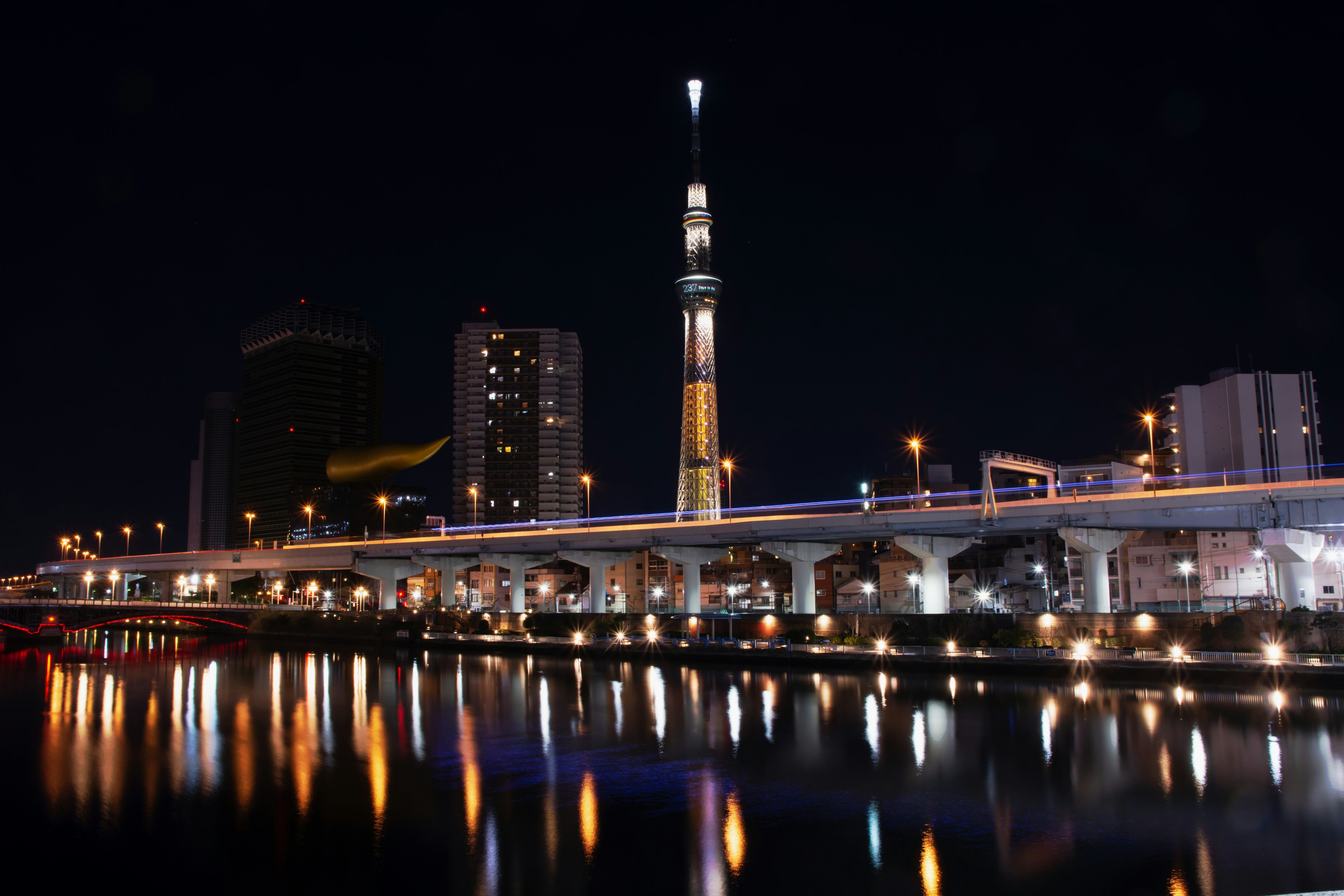 Tokyo Skytree illuminato di notte con riflesso sul fiume