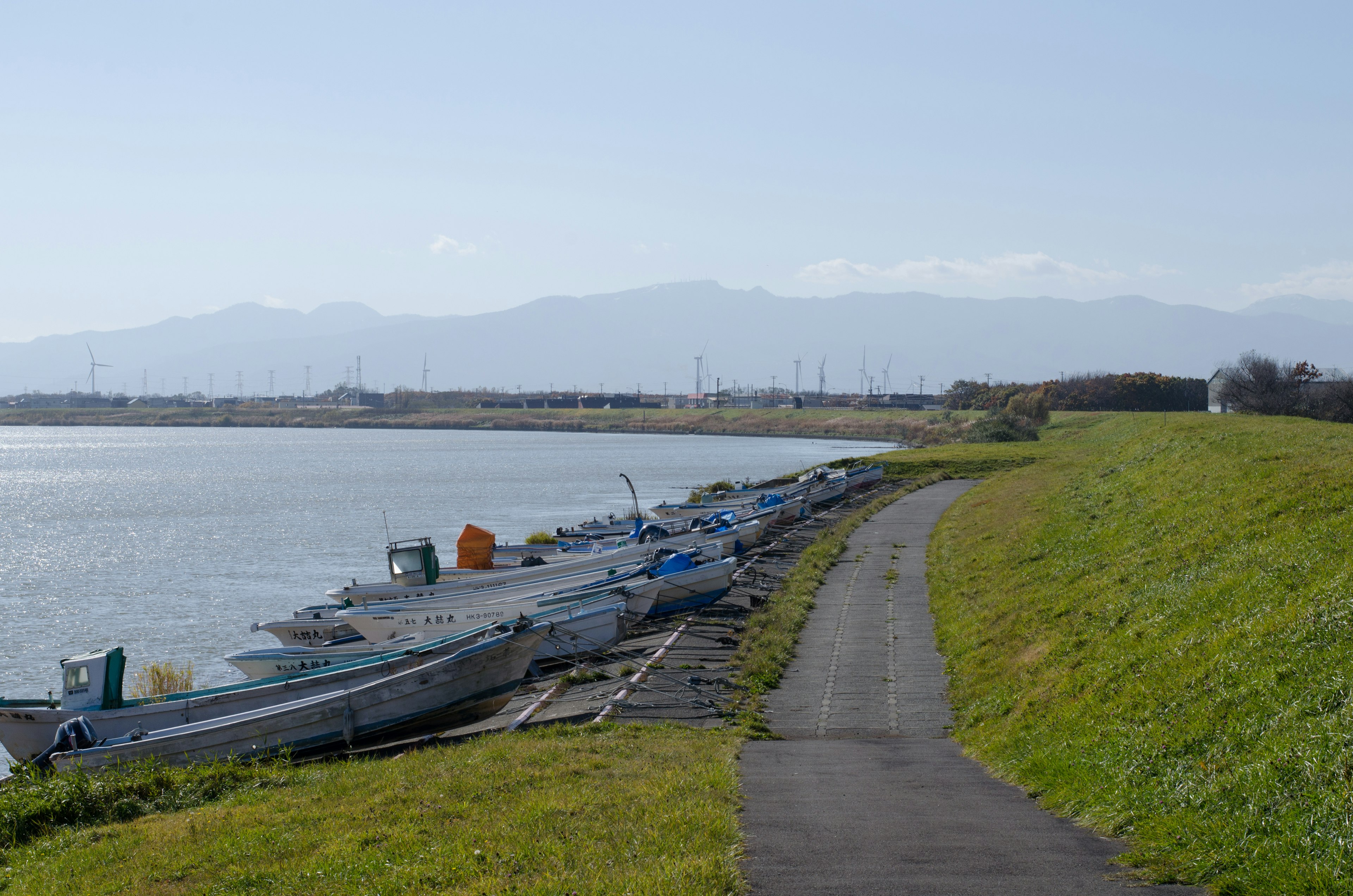 静かな川の沿岸に停泊する小型ボートと緑の草地