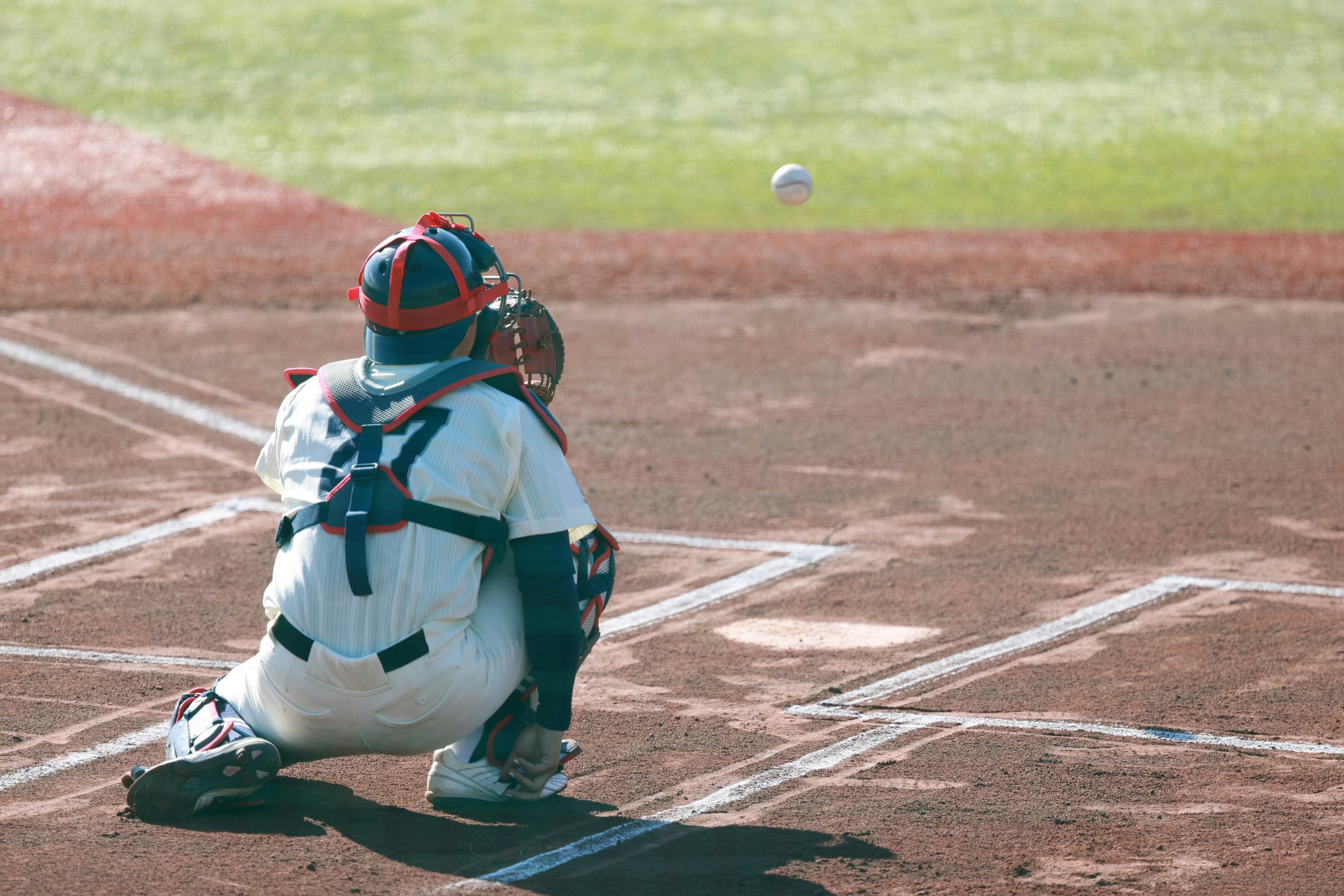 A baseball catcher waiting for a pitch