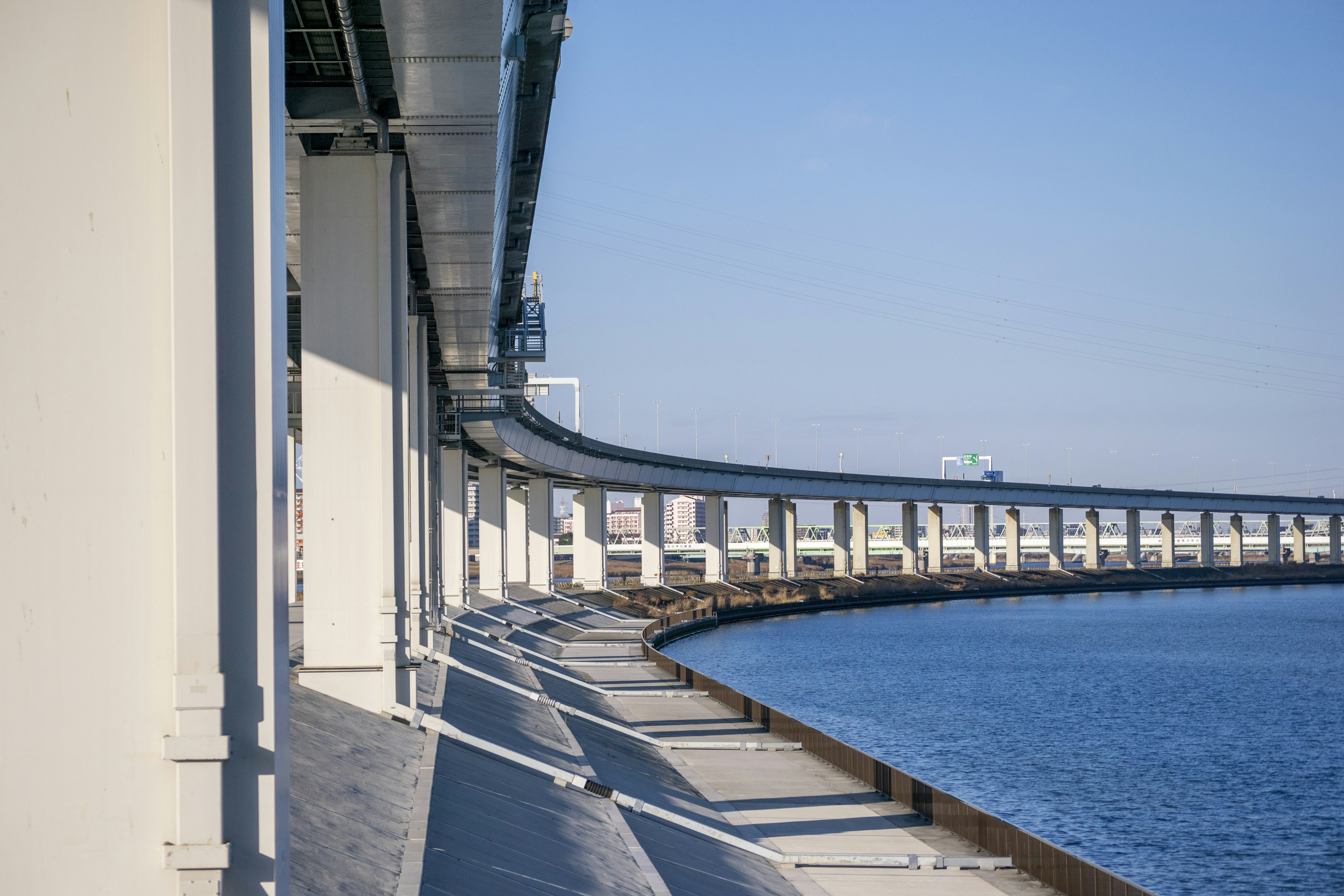 Gebogener Brücke über Wasser mit Schatten