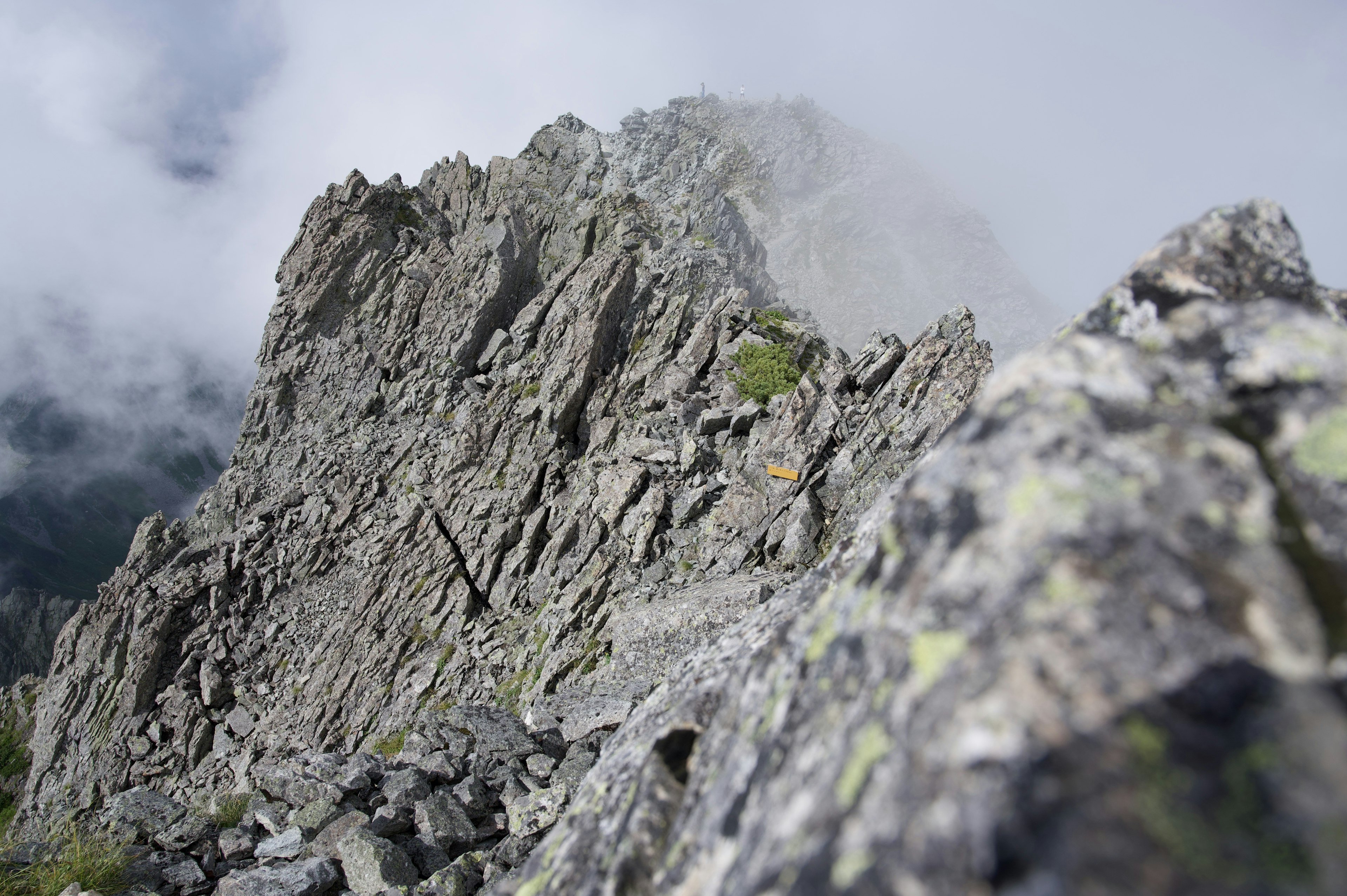 岩の尖った山の頂上に近い風景 雲がかかっている