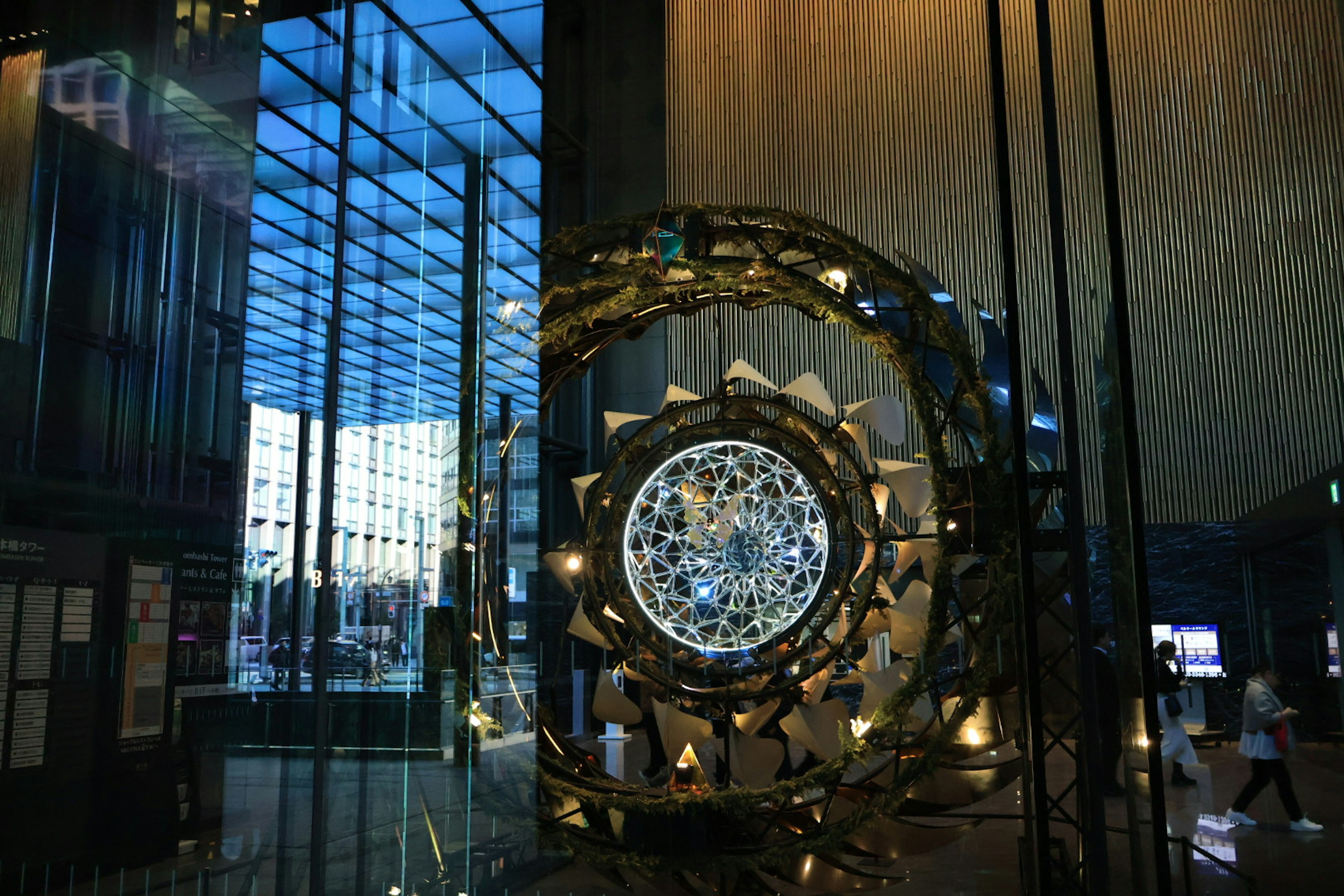 Interior of a modern building featuring a decorative device and a water wall visible through glass