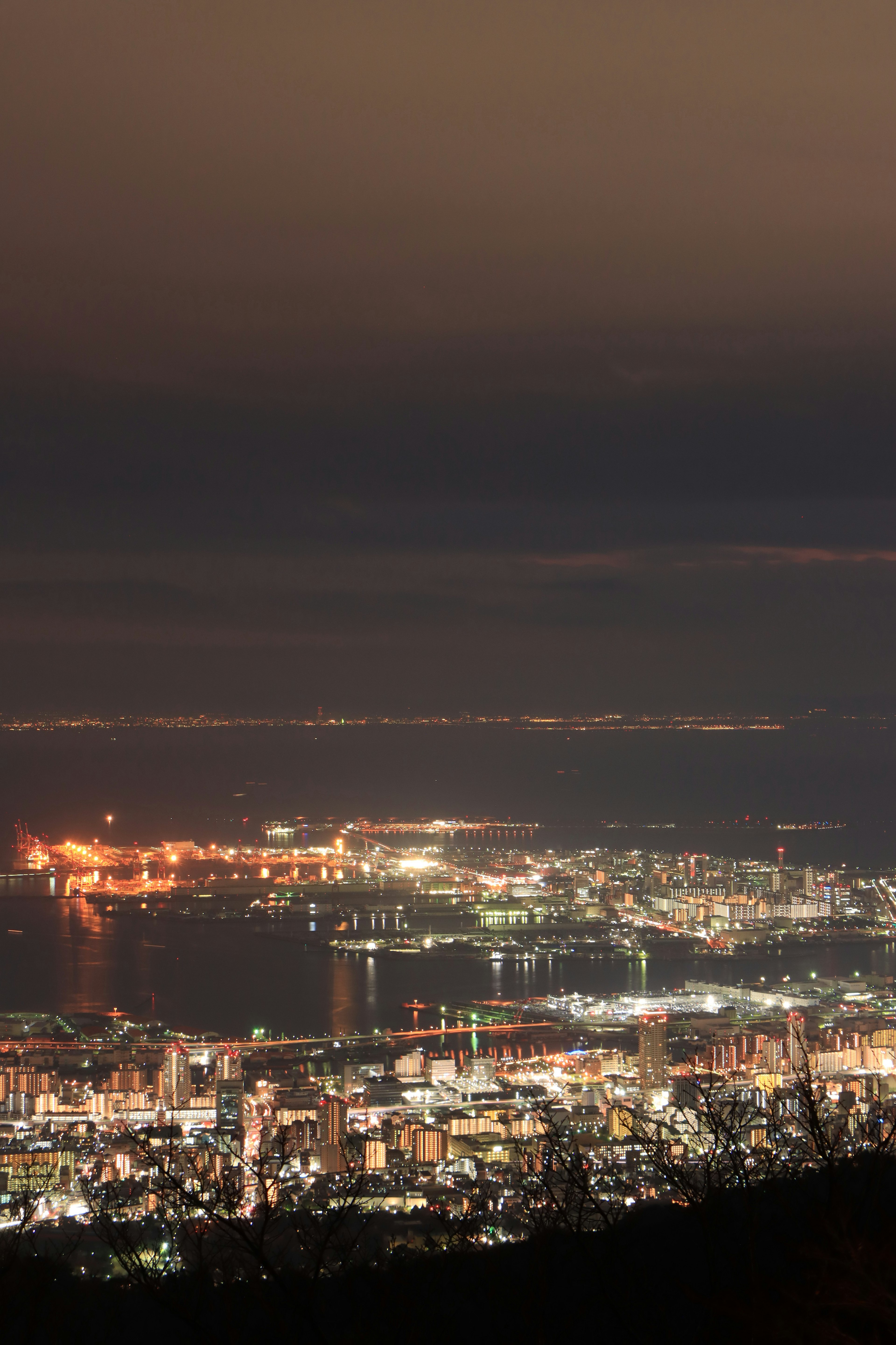 Vista nocturna de las luces de la ciudad a lo largo de la costa