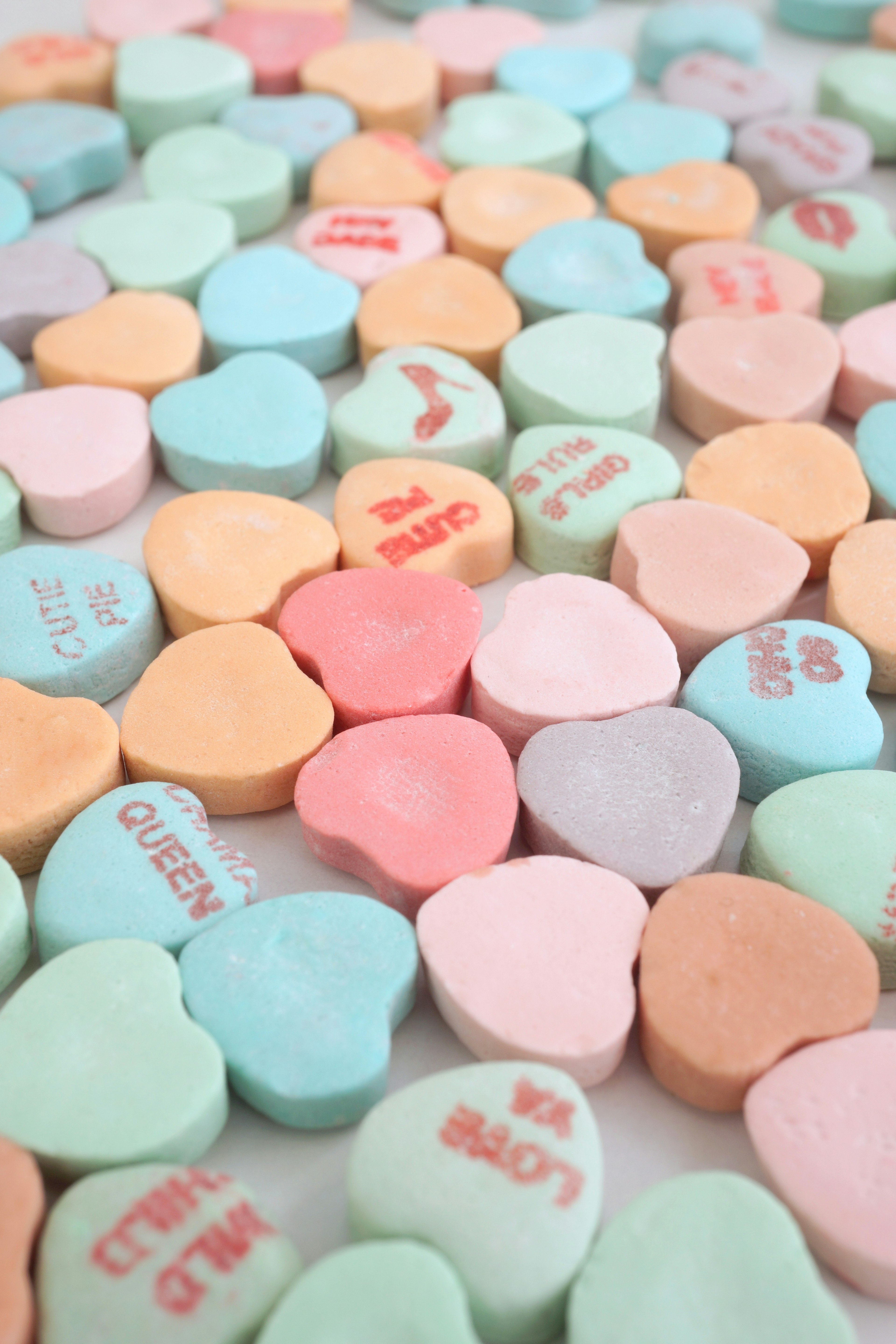 Colorful heart-shaped candies scattered across a surface