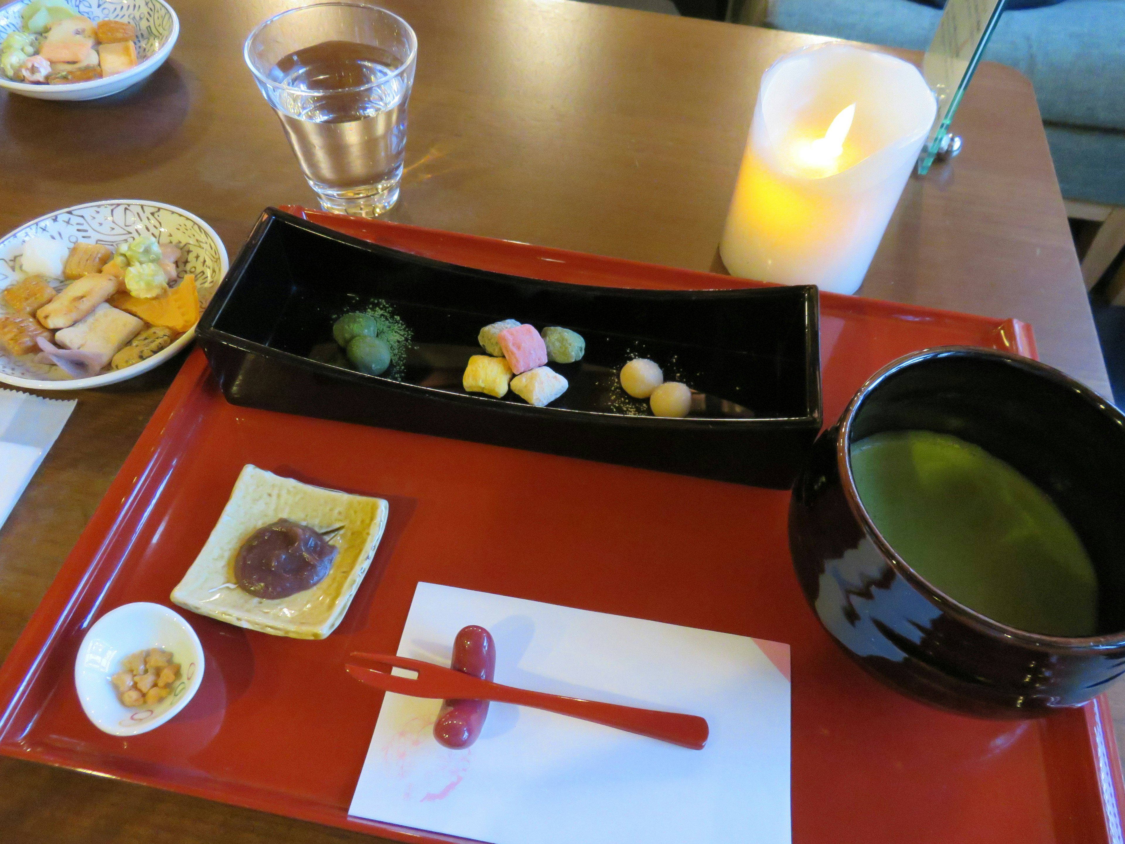 Japanese meal plate featuring colorful wagashi and matcha tea