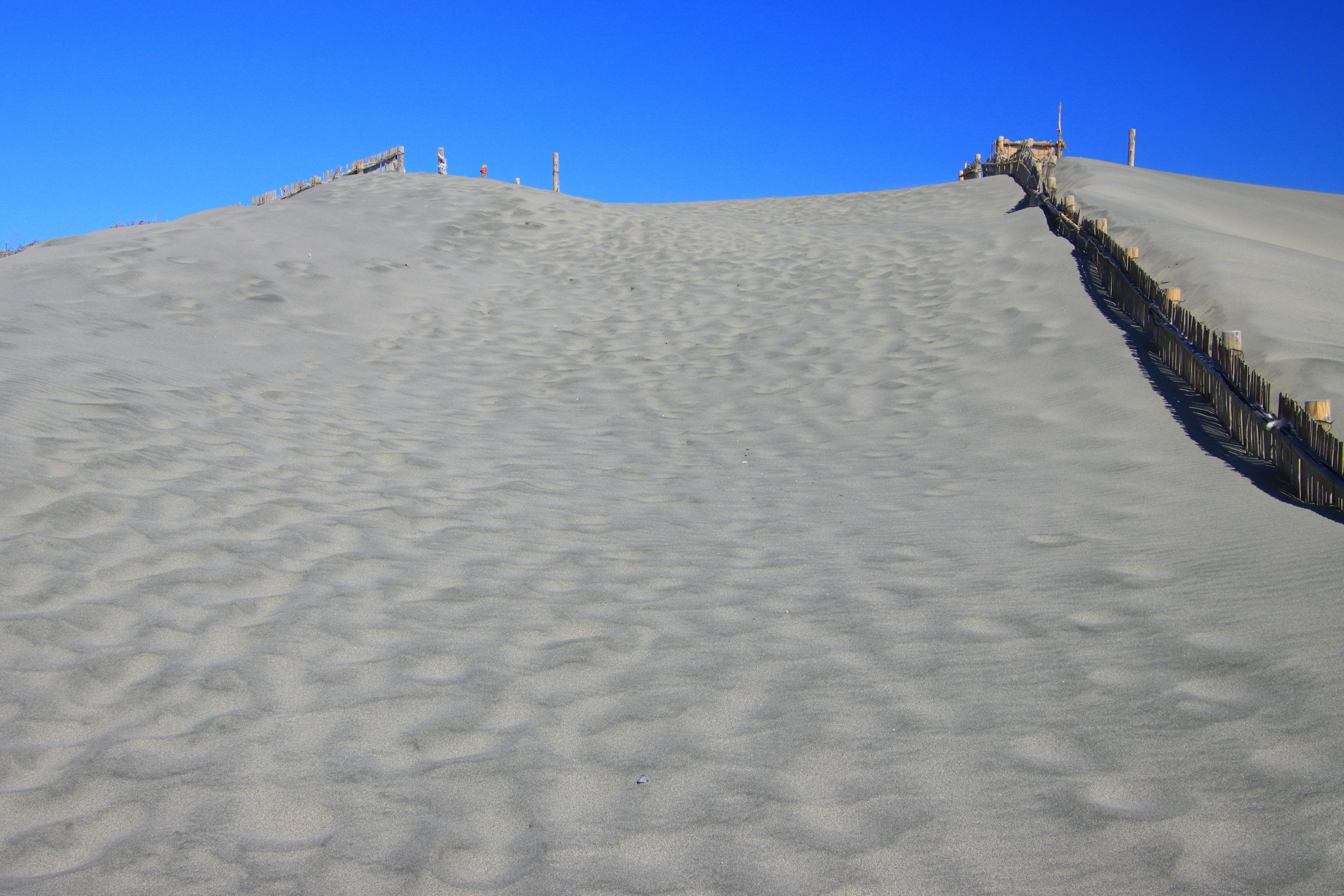 Paisaje de dunas de arena con cielo azul y textura de arena