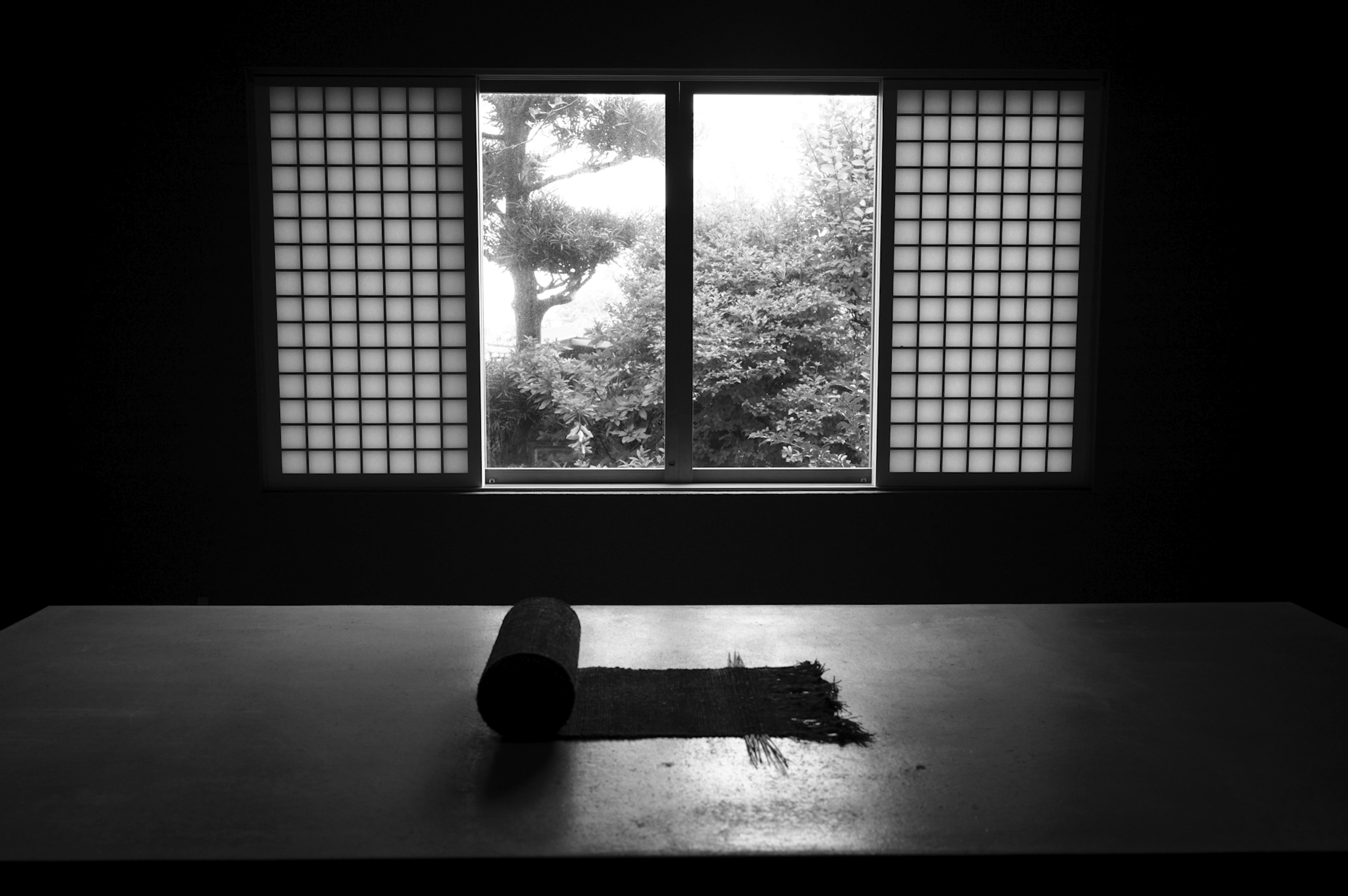 Interior en blanco y negro con mesa y vista de la ventana