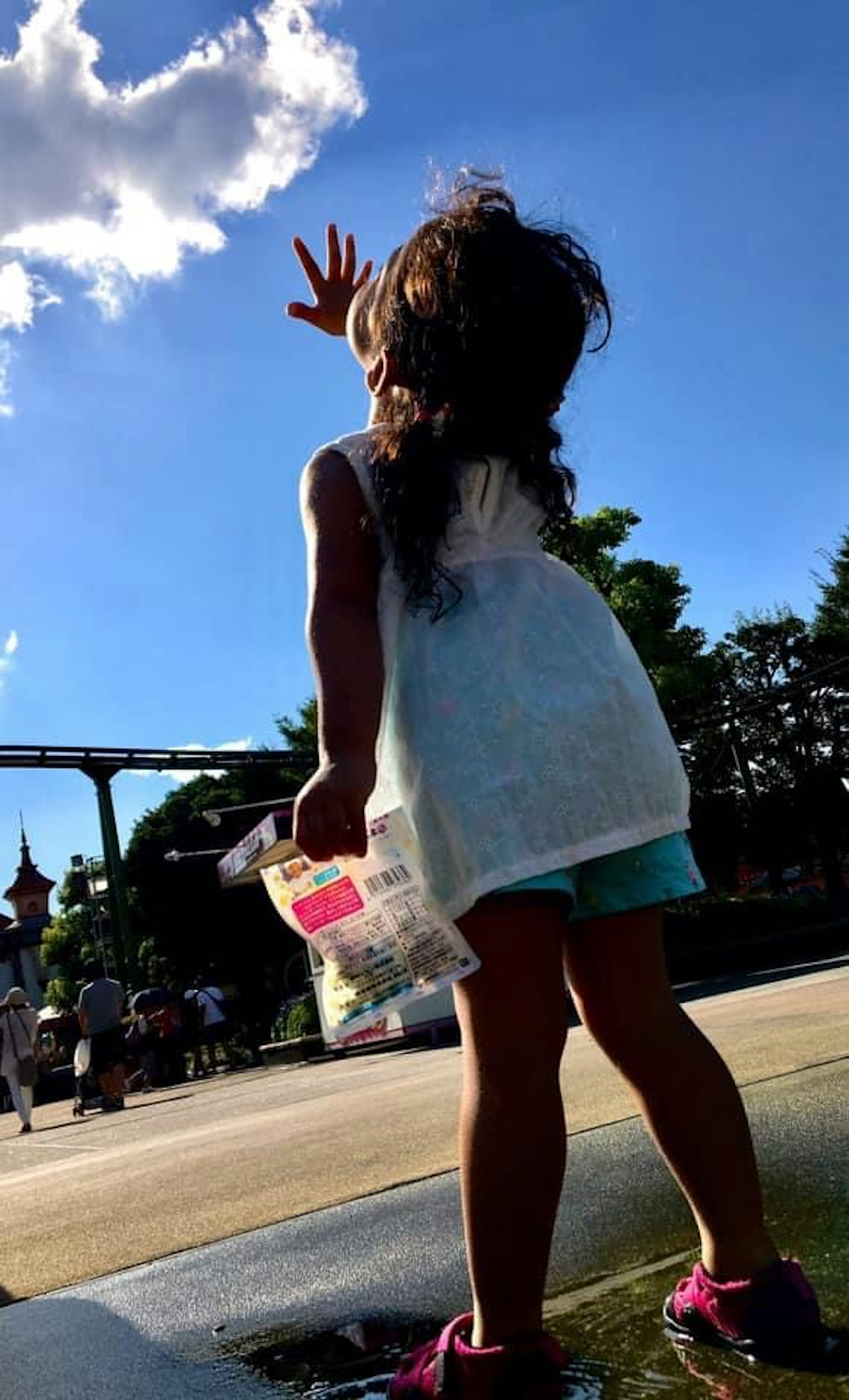 Bambino che si allunga sotto un cielo blu