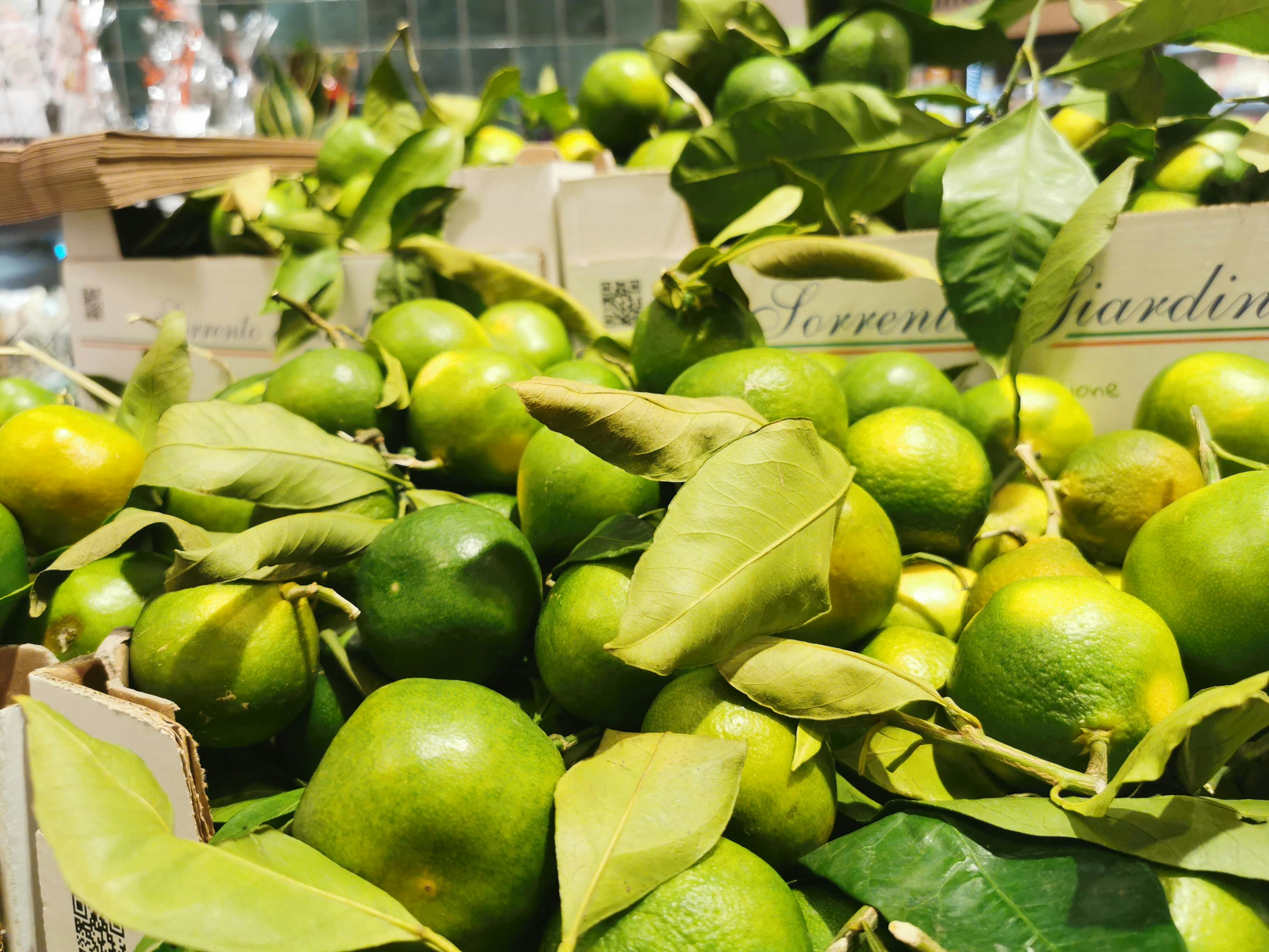 Green limes with leaves displayed in a market setting