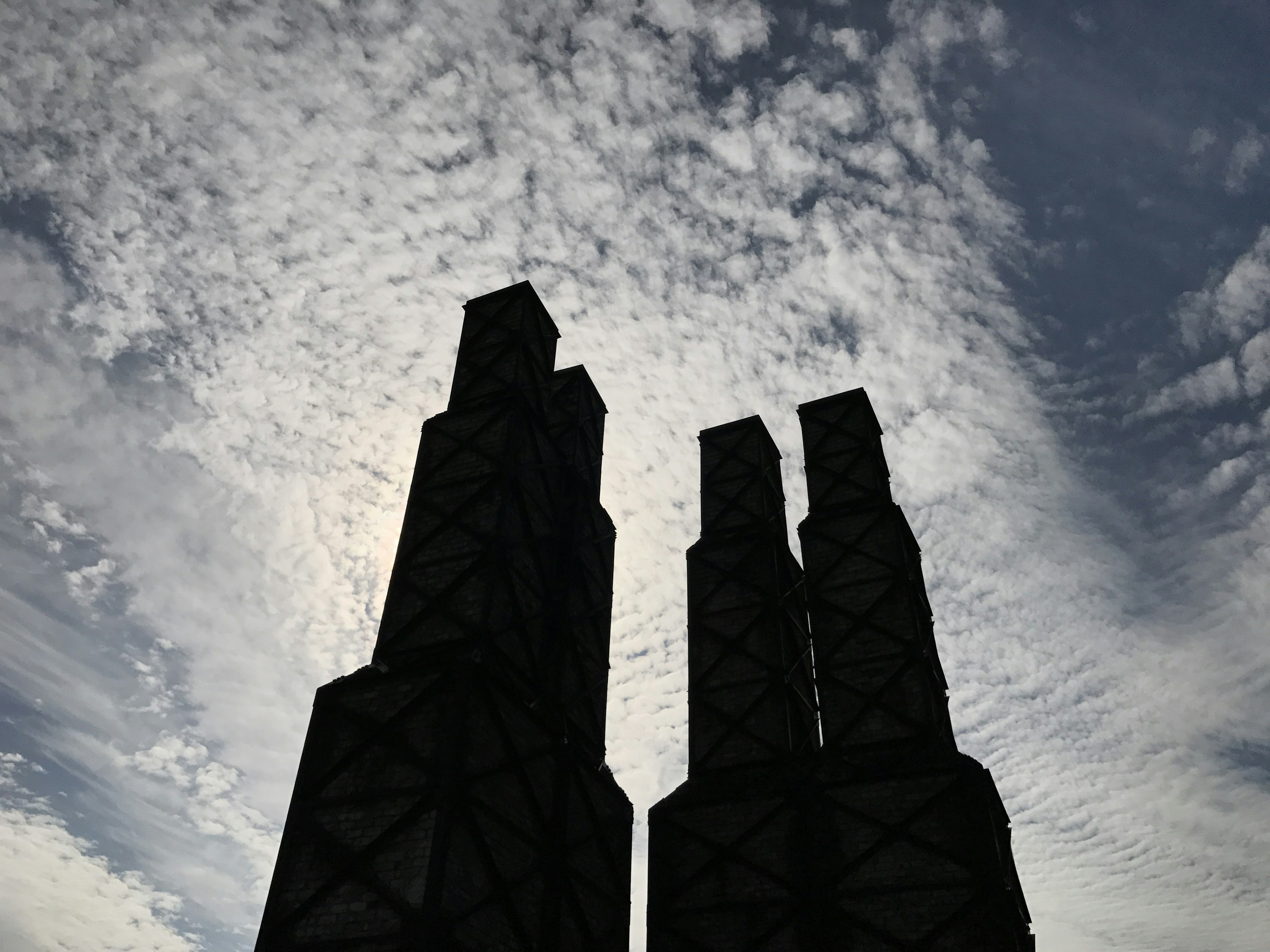 Silhouetted skyscrapers towering against a cloudy sky