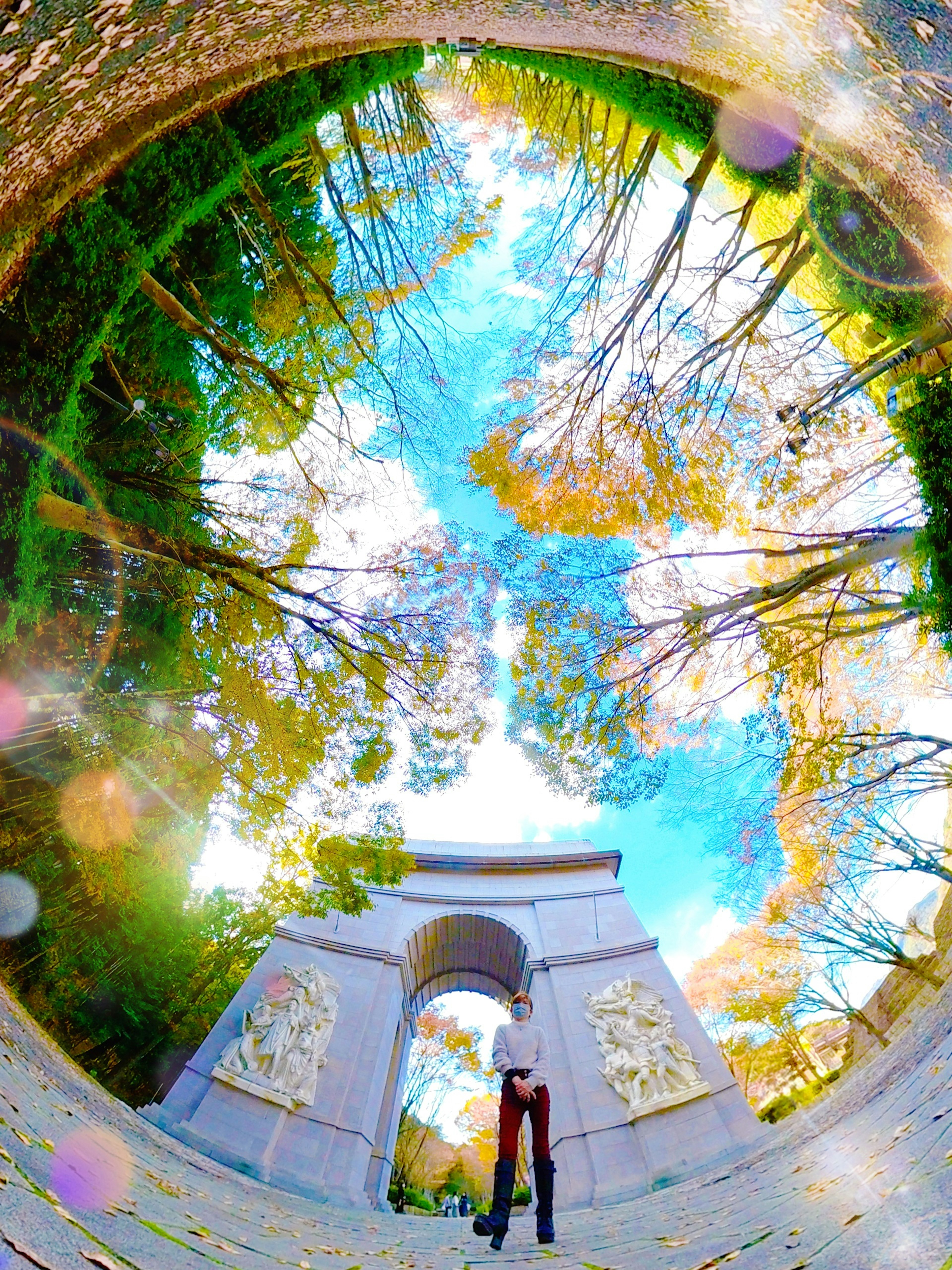 Archway surrounded by green trees and vibrant blue sky