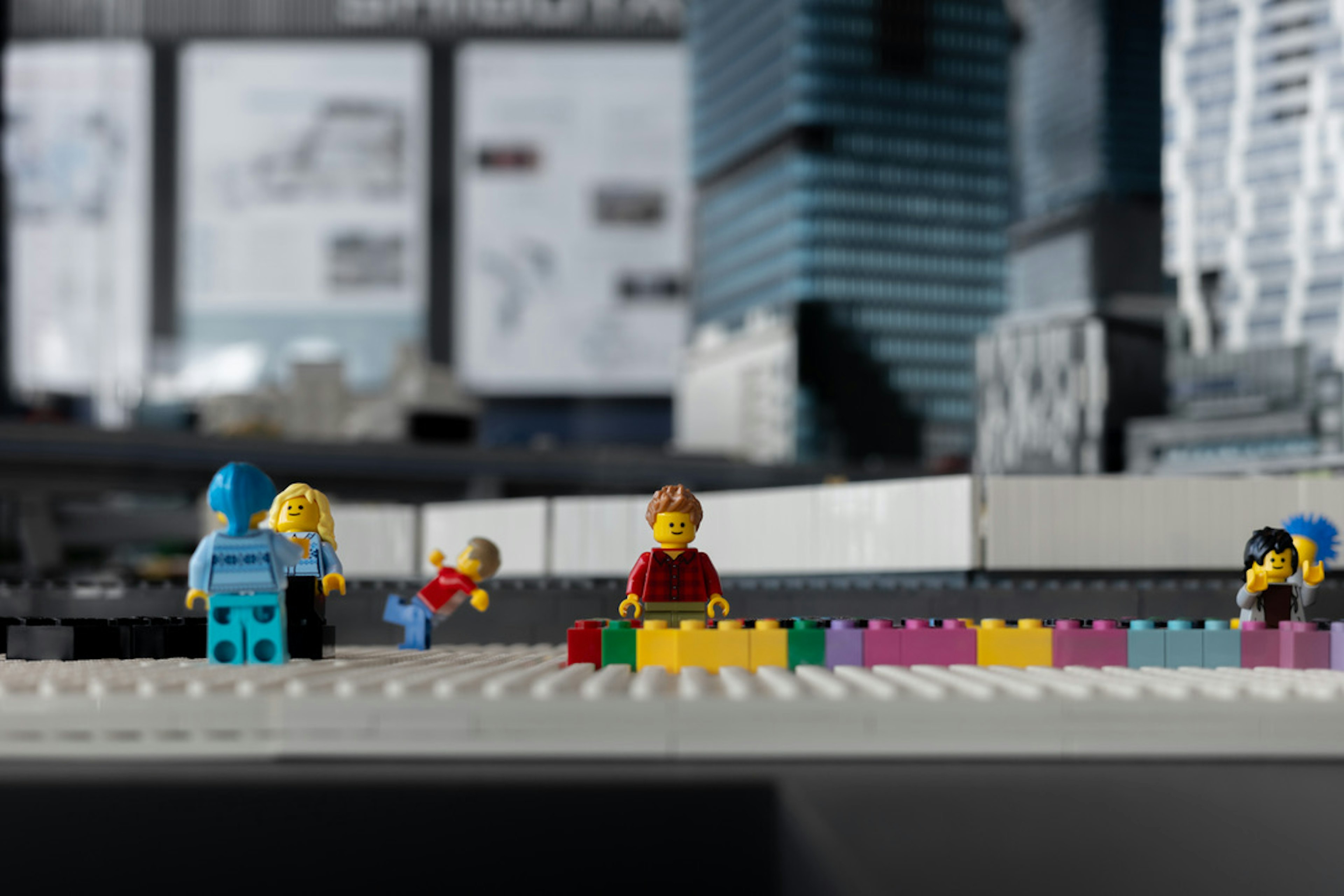 Scène avec des mini-figurines LEGO jouant des blocs colorés disposés en ligne