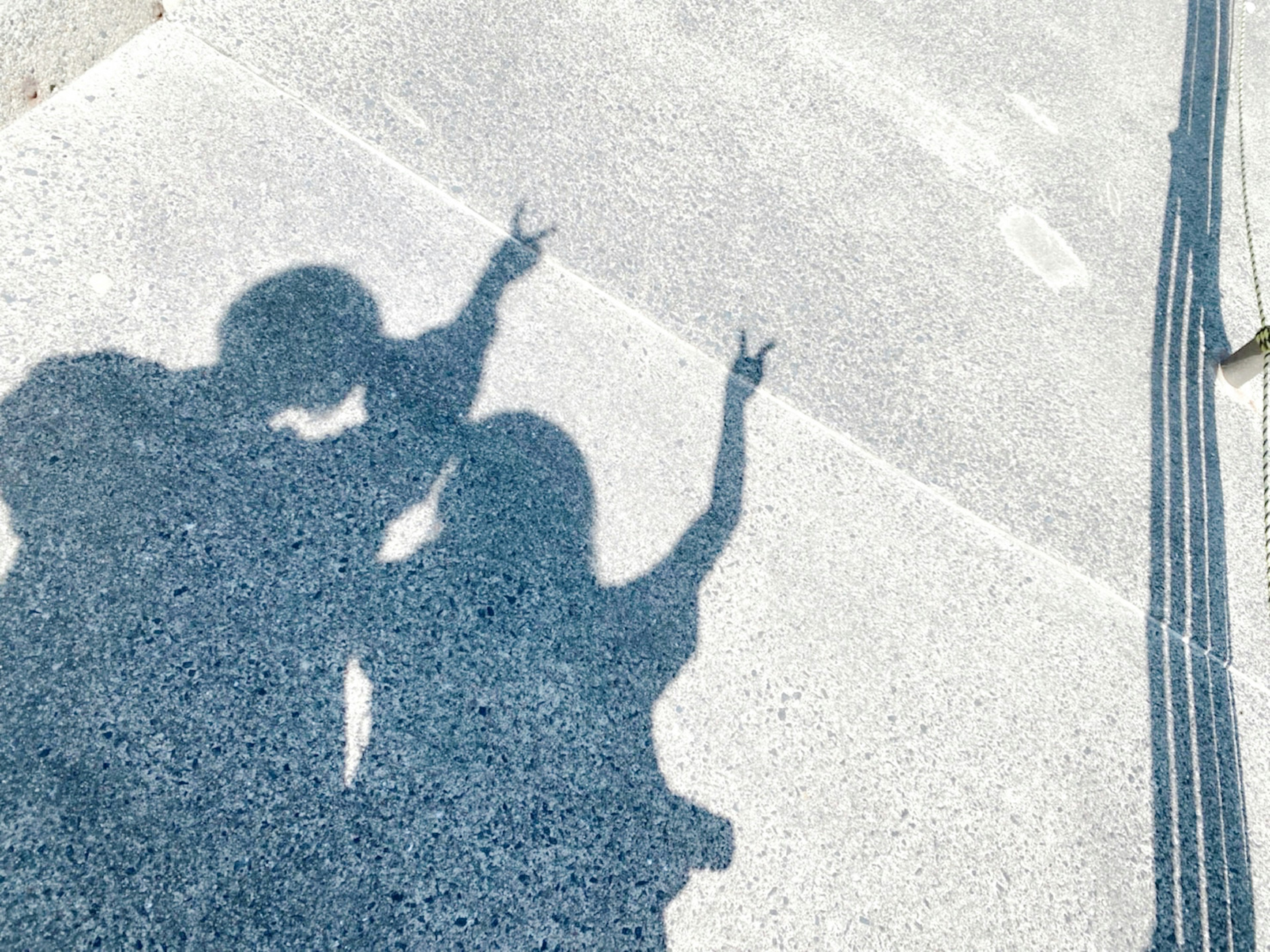 Shadows of two people raising their hands