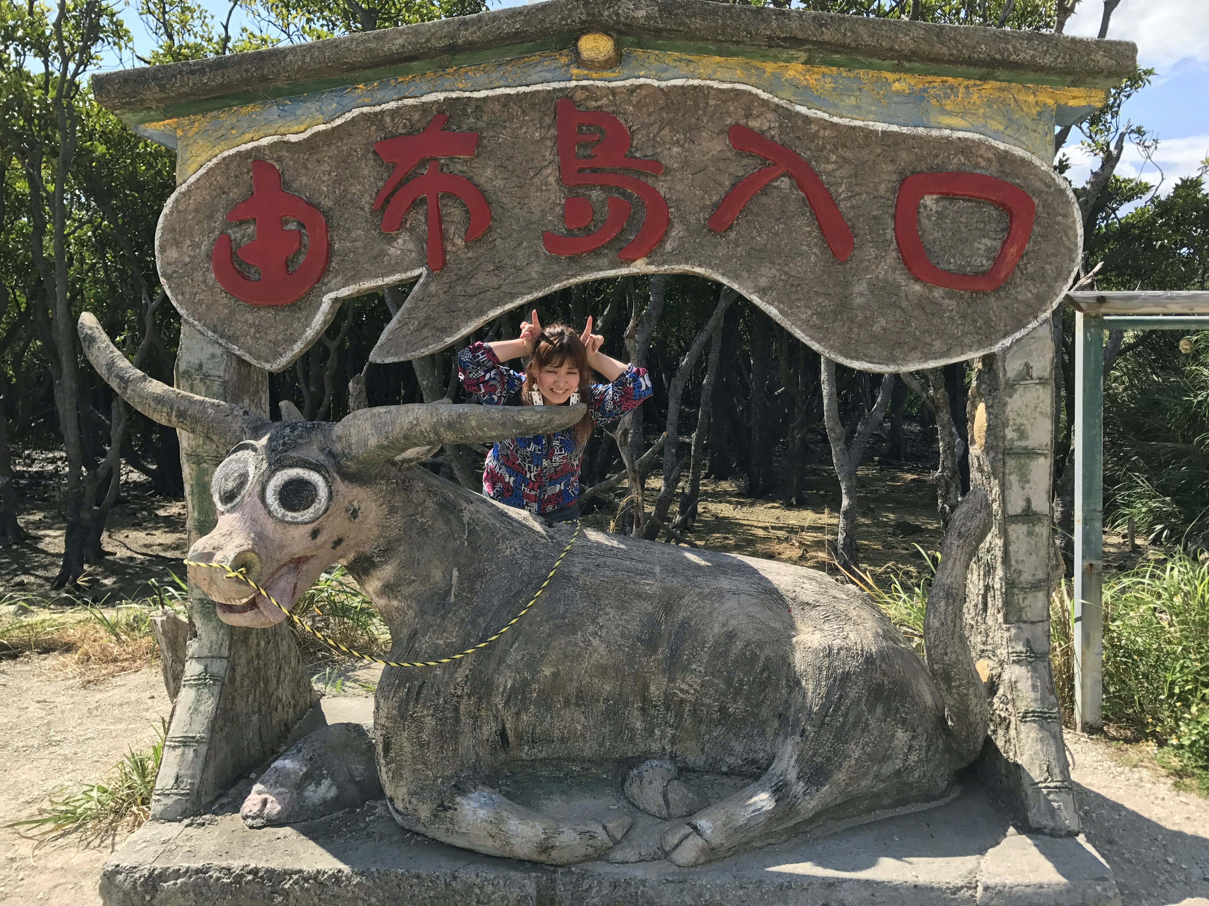 Entrada con una estatua de toro de piedra y un letrero