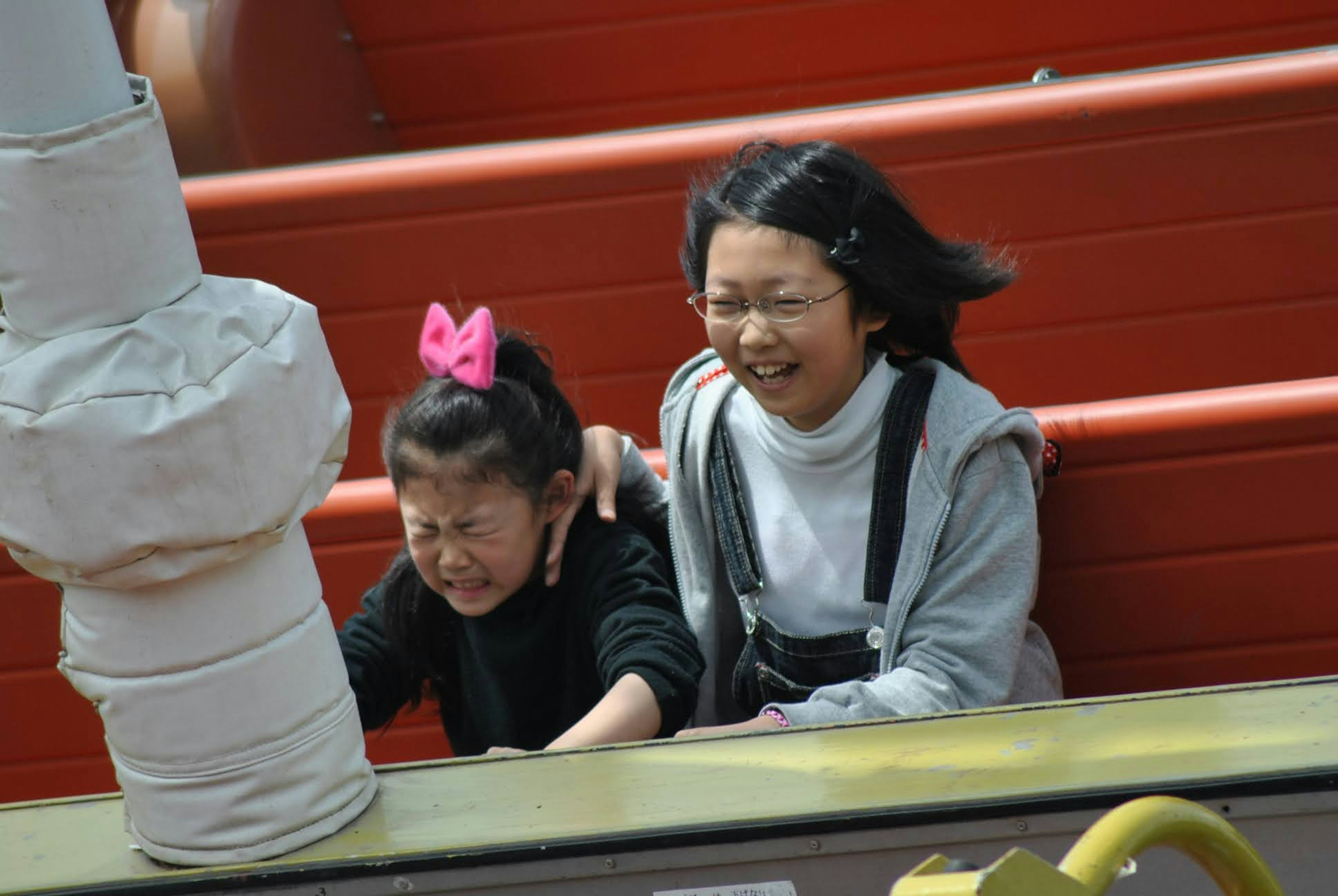 Children enjoying a theme park ride with expressions of joy and surprise