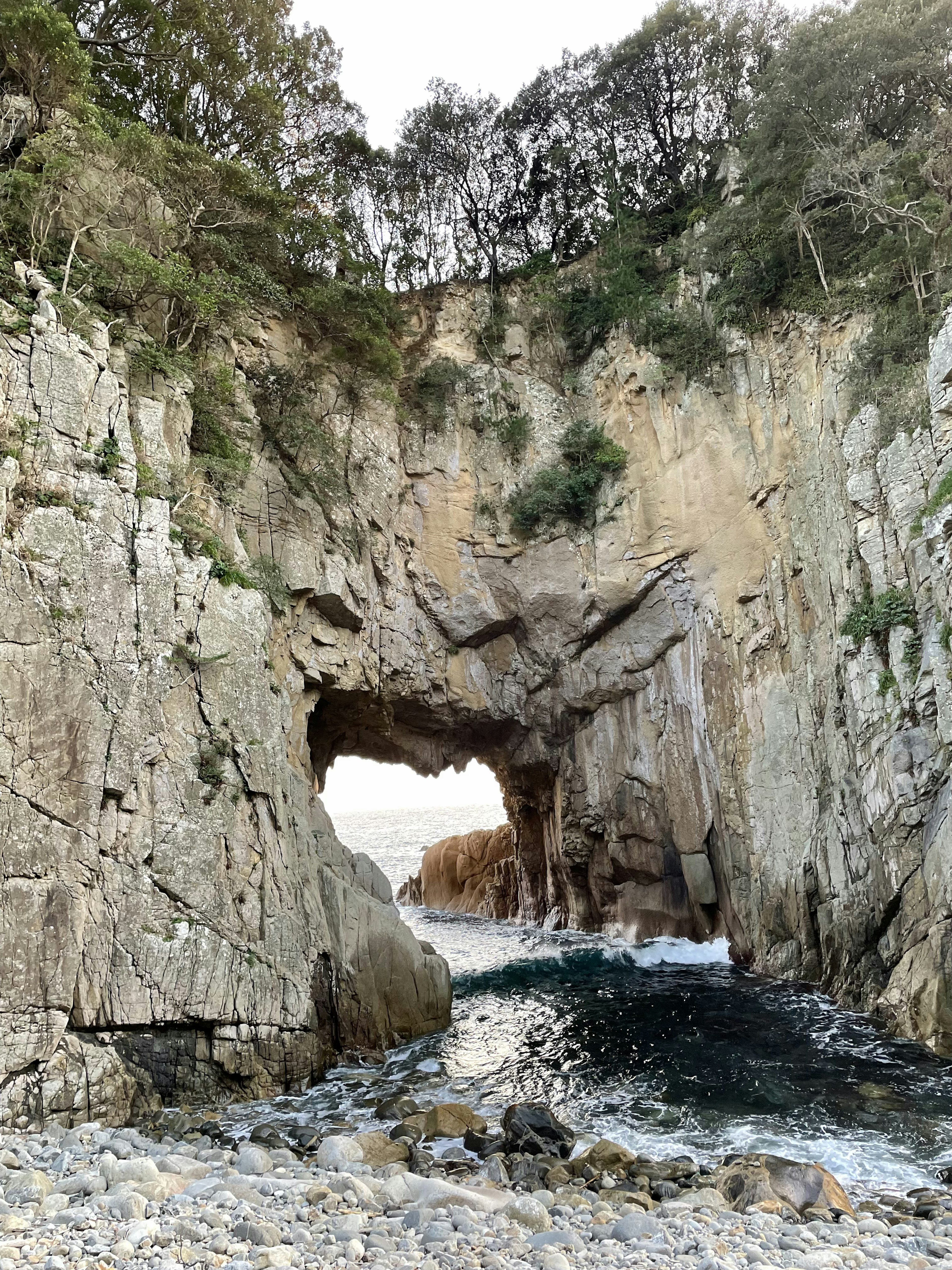 Rock formation with an arch and ocean waves crashing through