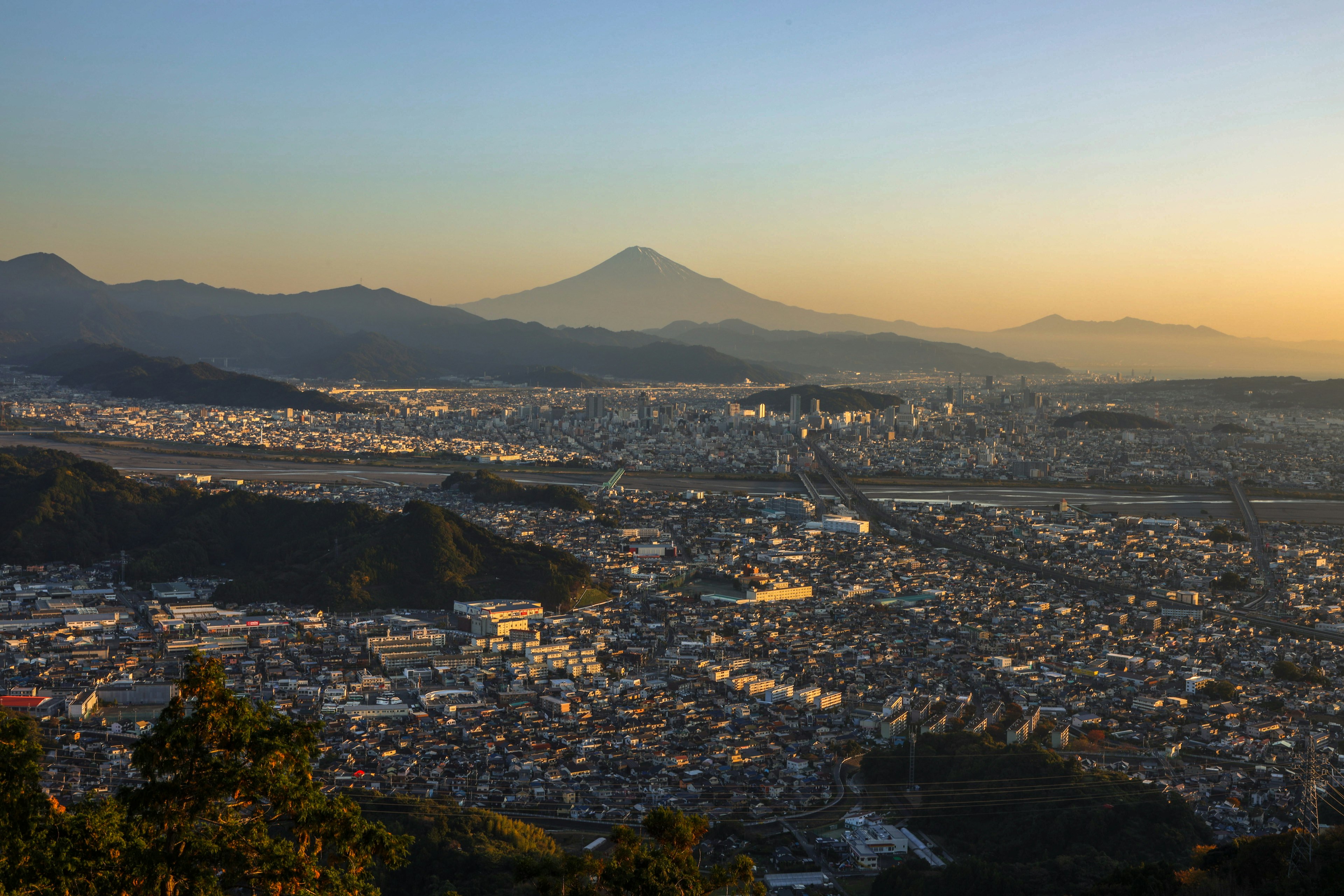 Vista panoramica di una città con montagne al tramonto